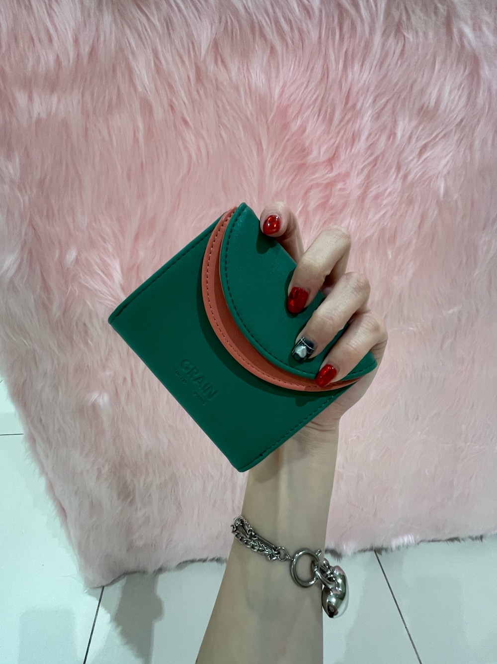 グリーン系の財布を着用したレディースの冬コーディネートの1枚目の写真