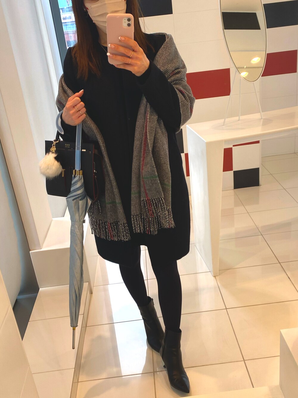 ブラック系のワンピース、ブラック系のハンドバッグ、ブラック系のブーツを着用したレディースの冬コーディネートの1枚目の写真