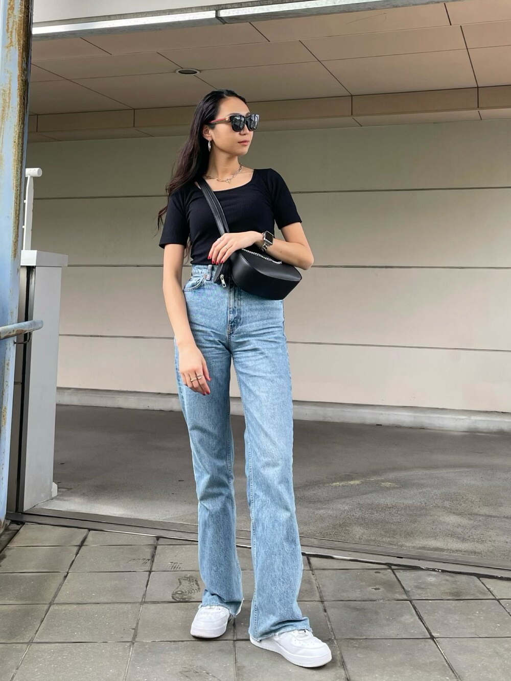 ブラック系のTシャツ/カットソー、ブラック系のショルダーバッグを着用したレディースの春コーディネートの1枚目の写真