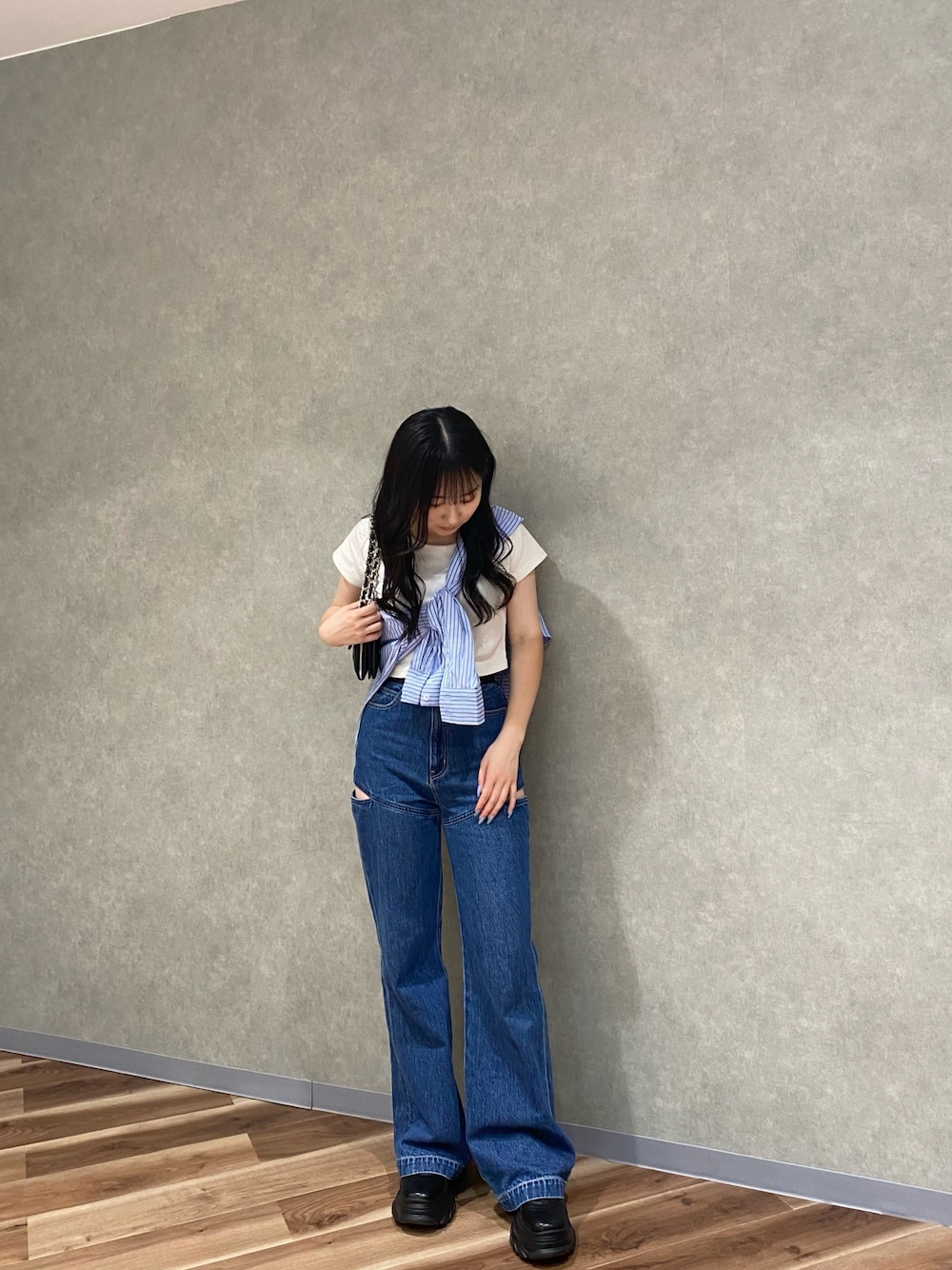 ブラック系のスニーカー、ブルー系のシャツ/ブラウス、ホワイト系のTシャツ/カットソーを着用したレディースの春コーディネートの1枚目の写真