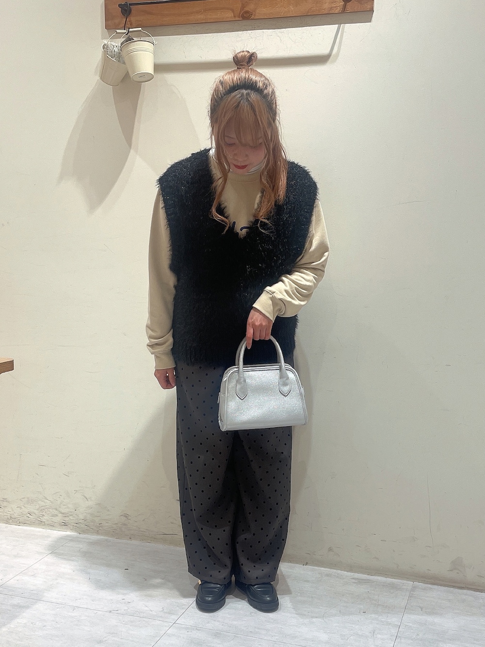 イエロー系のTシャツ/カットソー、ホワイト系のTシャツ/カットソー、ブラック系のニット/セーターを着用したレディースの冬コーディネートの1枚目の写真