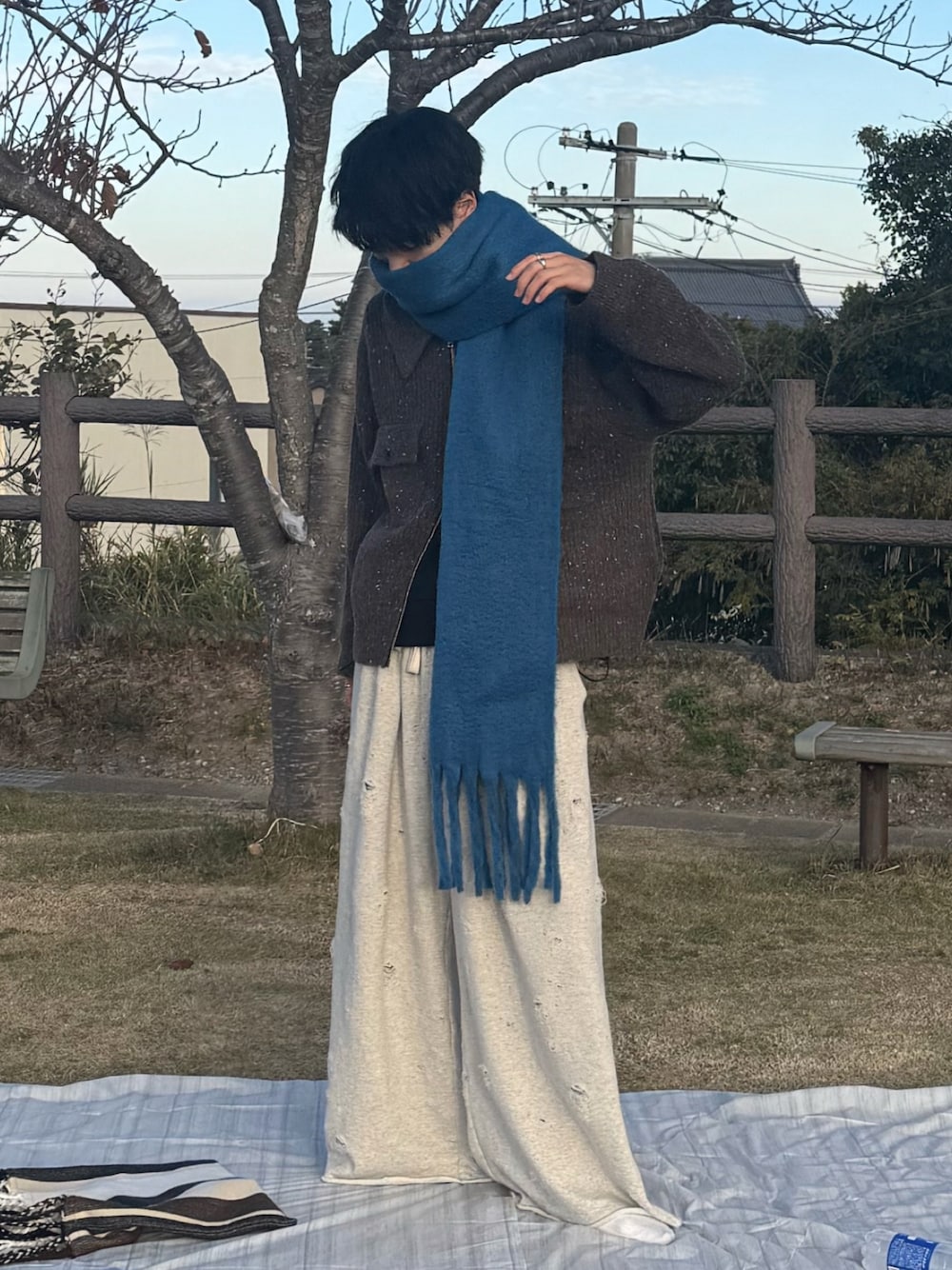 ブラウン系のニット/セーター、ホワイト系のスウェットパンツ、ブルー系のマフラーを着用したメンズの秋コーディネートの1枚目の写真