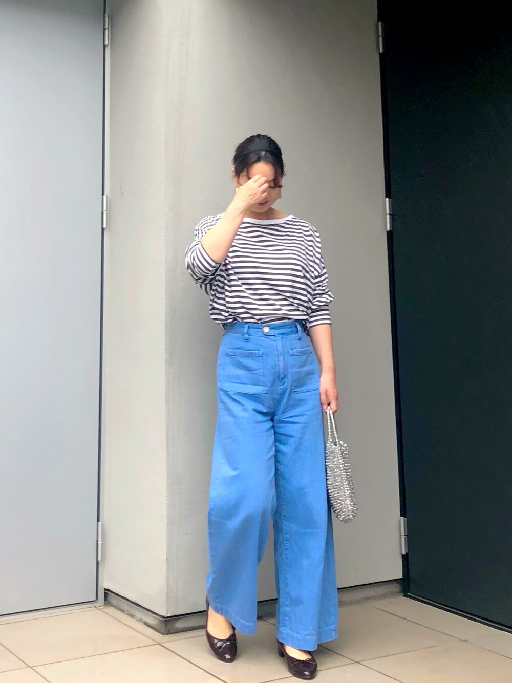 グリーン系のTシャツ/カットソー、ブルー系のその他パンツ、ブラウン系のレインシューズを着用したレディースの秋コーディネートの1枚目の写真