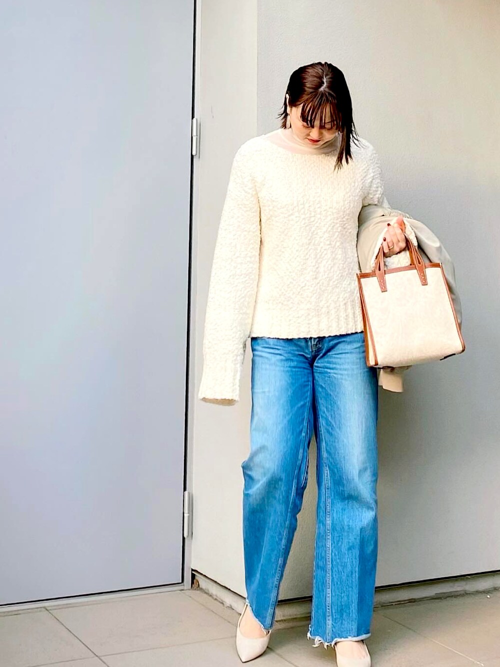 ホワイト系のTシャツ/カットソー、ホワイト系のニット/セーター、ブルー系のデニムパンツを着用したレディースの冬コーディネートの1枚目の写真