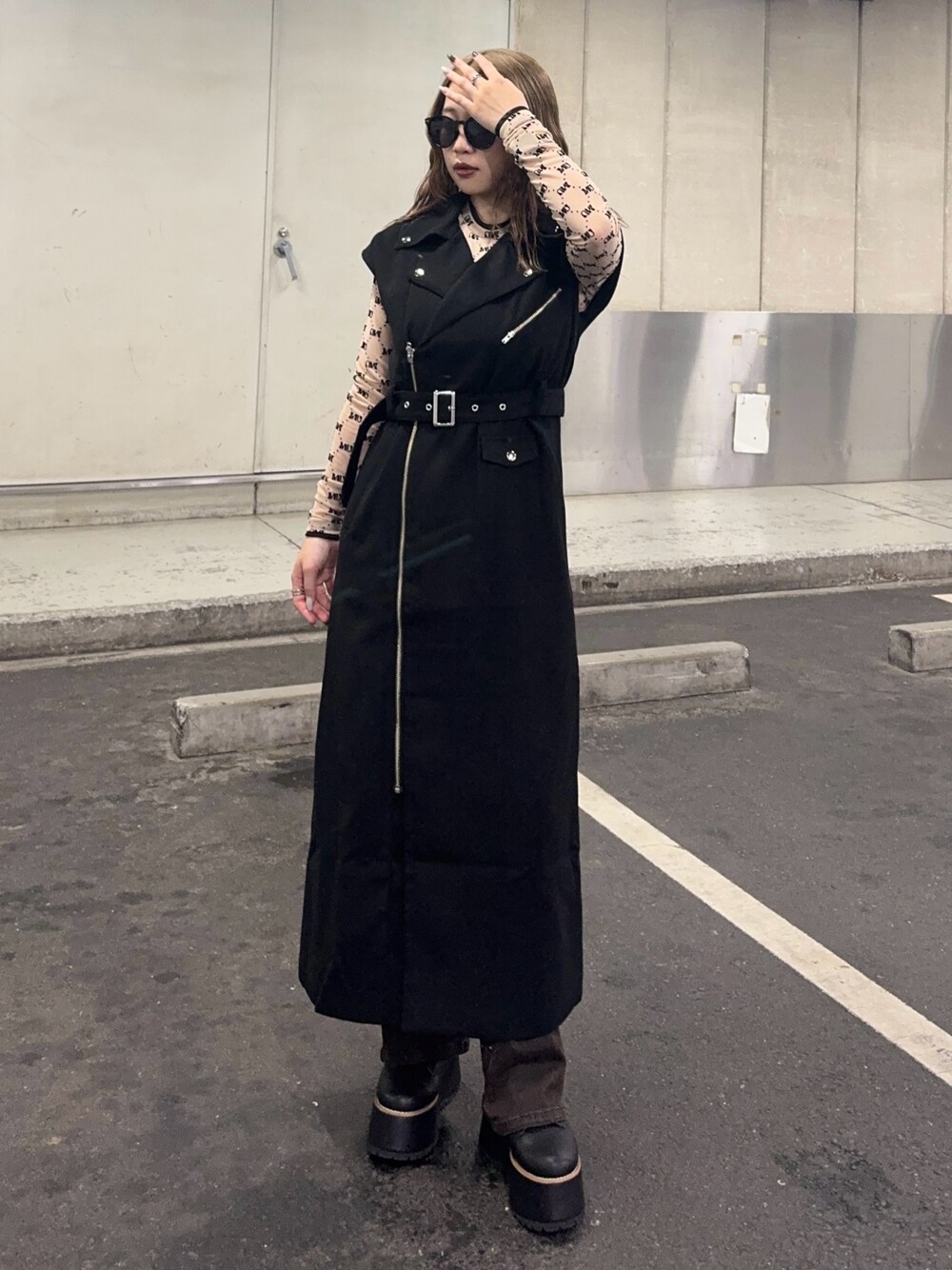 ブラウン系のデニムパンツ、ベージュ系のTシャツ/カットソー、ブラック系のワンピースを着用したレディースの秋コーディネートの1枚目の写真