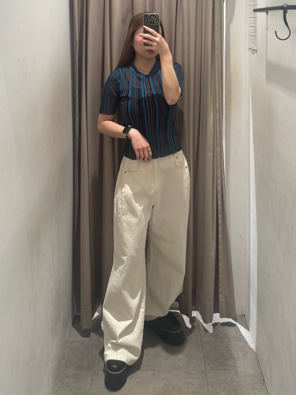 ホワイト系のデニムパンツ、ブルー系のニット/セーター、ブラック系のブーツを着用したレディースの春コーディネートの1枚目の写真