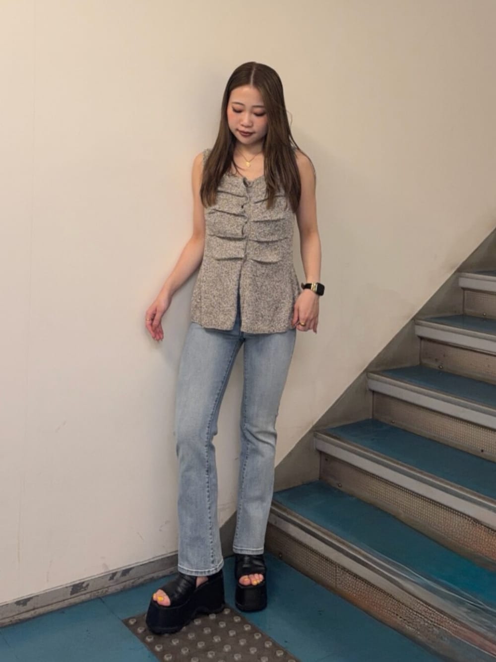ブラック系のブーツ、ブルー系のデニムパンツ、ベージュ系のタンクトップを着用したレディースの夏コーディネートの1枚目の写真
