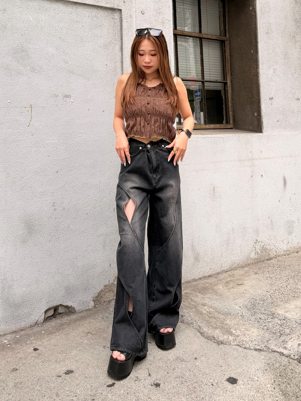 ブラウン系のキャミソール、ブラック系のデニムパンツ、ブラック系のブーツを着用したレディースの夏コーディネートの1枚目の写真