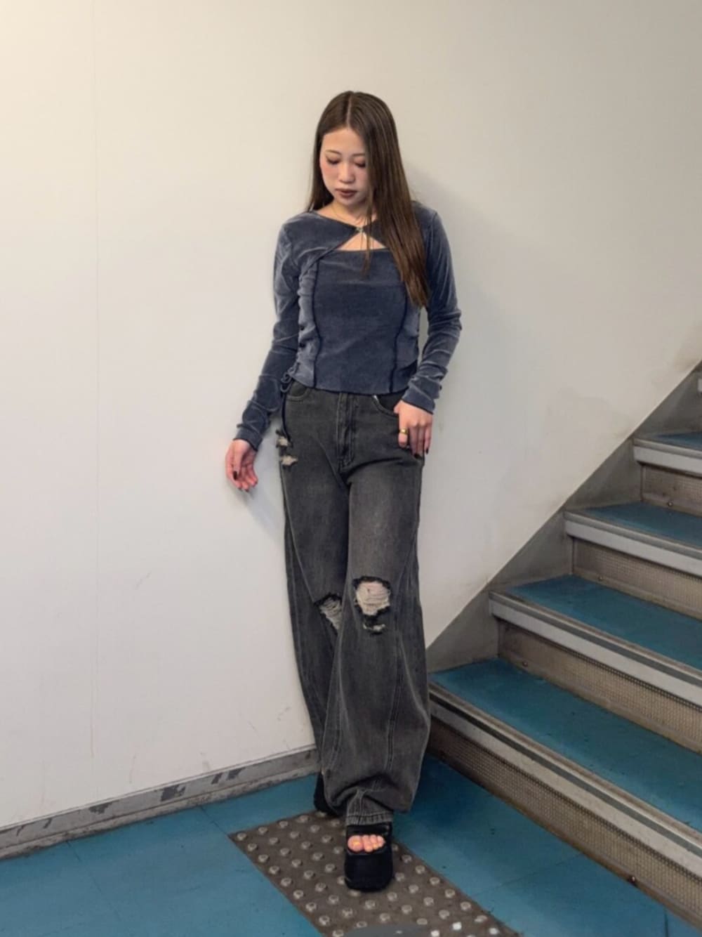 グレー系のデニムパンツ、ブラック系のブーツ、ブルー系のTシャツ/カットソーを着用したレディースの秋コーディネートの1枚目の写真