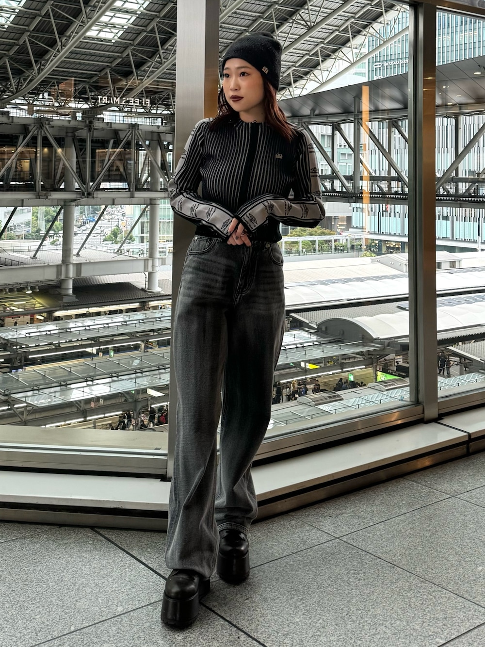 ブラック系のニット/セーター、ブラック系のデニムパンツ、ブラウン系のブーツを着用したレディースの秋コーディネートの1枚目の写真