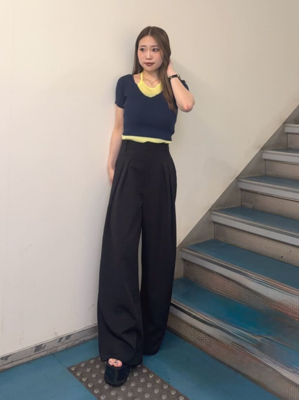 ブラック系のブーツ、ブラック系のスラックス、ブルー系のニット/セーターを着用したレディースの夏コーディネートの1枚目の写真