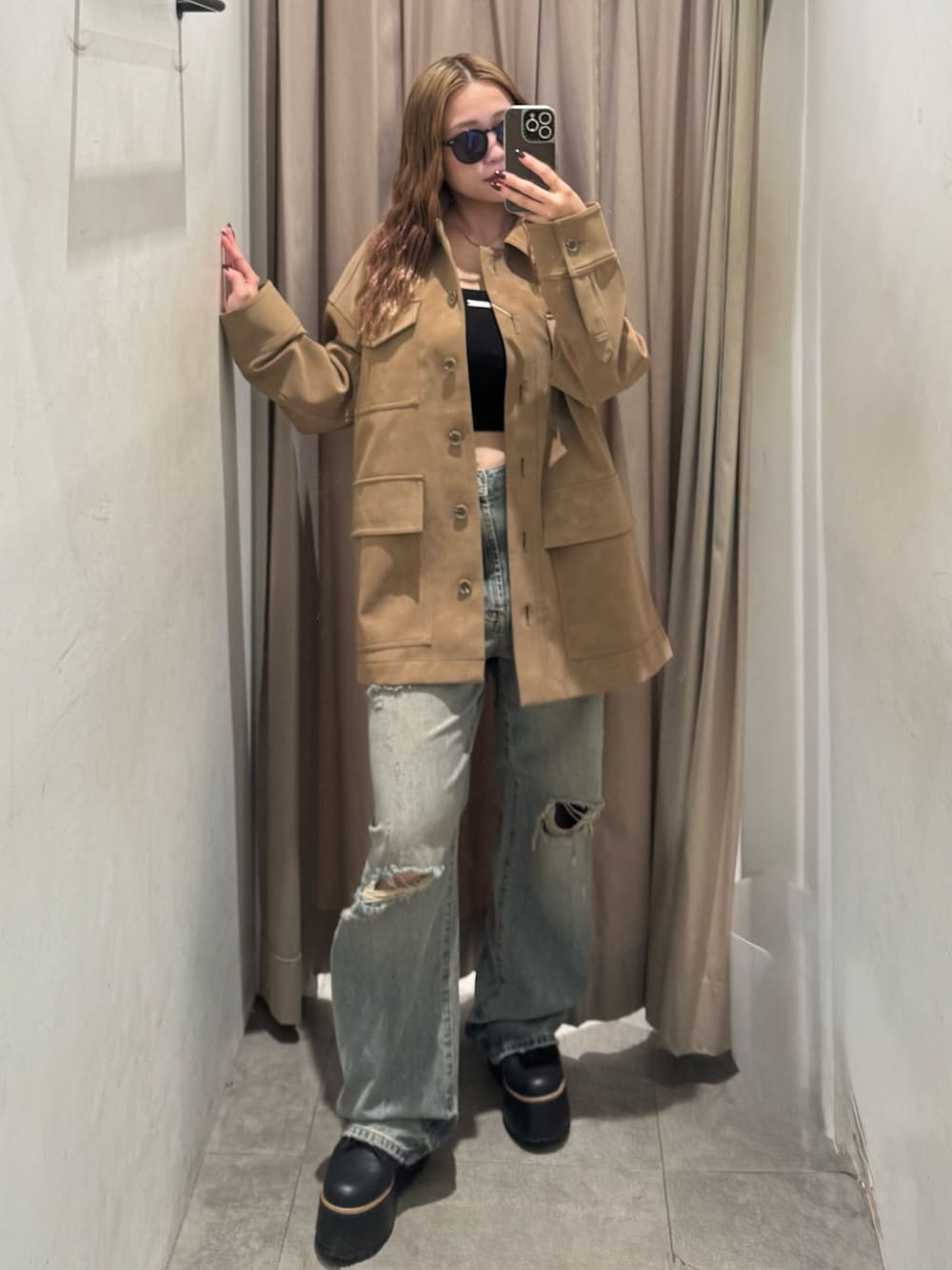 ベージュ系のその他アウター、ブルー系のデニムパンツ、ブラック系のブーツを着用したレディースの秋コーディネートの1枚目の写真