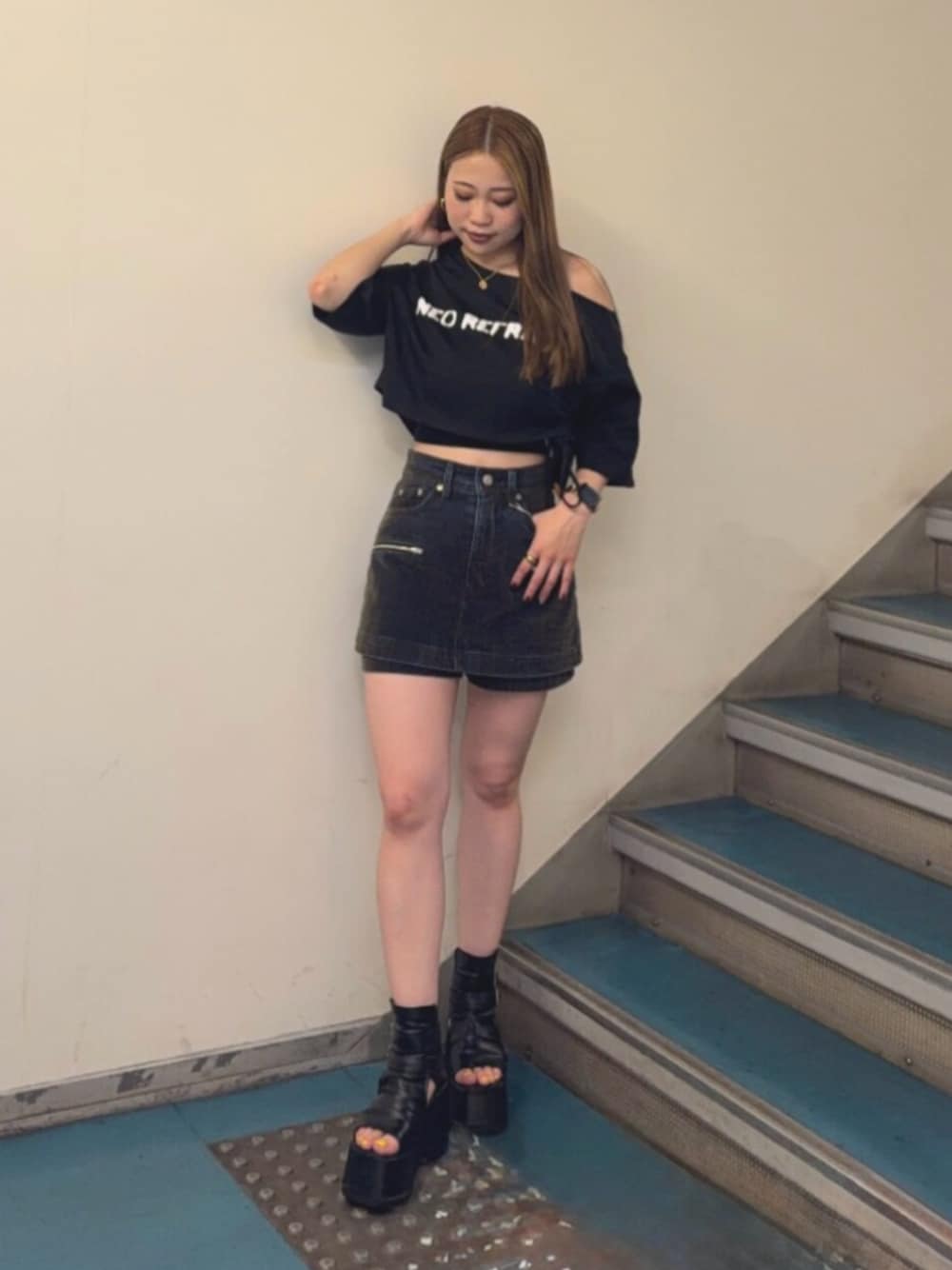 ブラック系のブーツ、ブラック系のTシャツ/カットソー、グリーン系のデニムスカートを着用したレディースの夏コーディネートの1枚目の写真