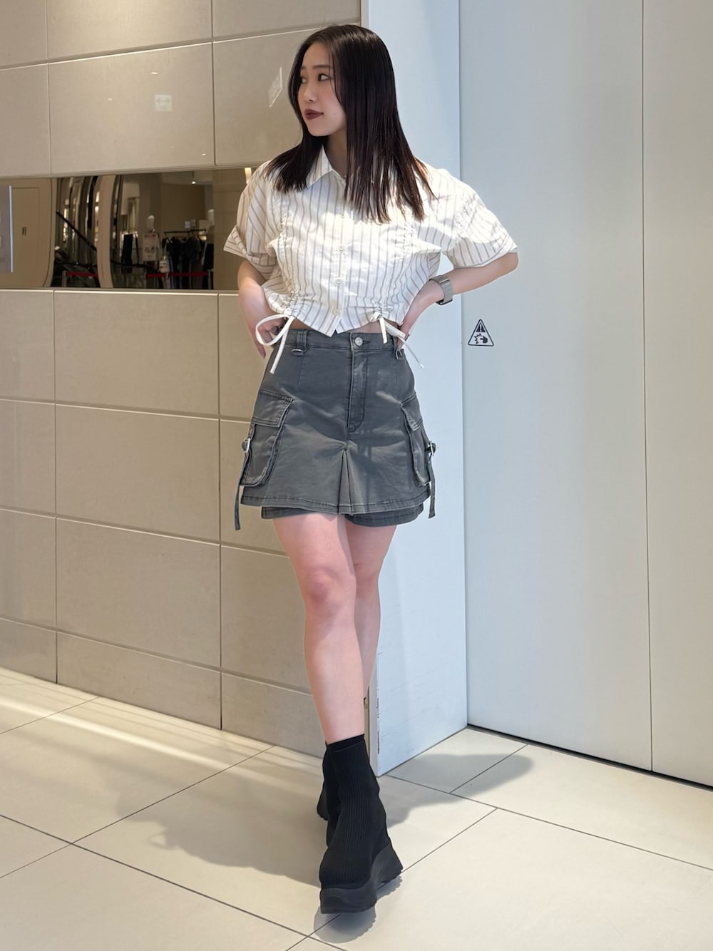 ホワイト系のシャツ/ブラウス、グレー系のスカート、ブラック系のブーツを着用したレディースの春コーディネートの1枚目の写真