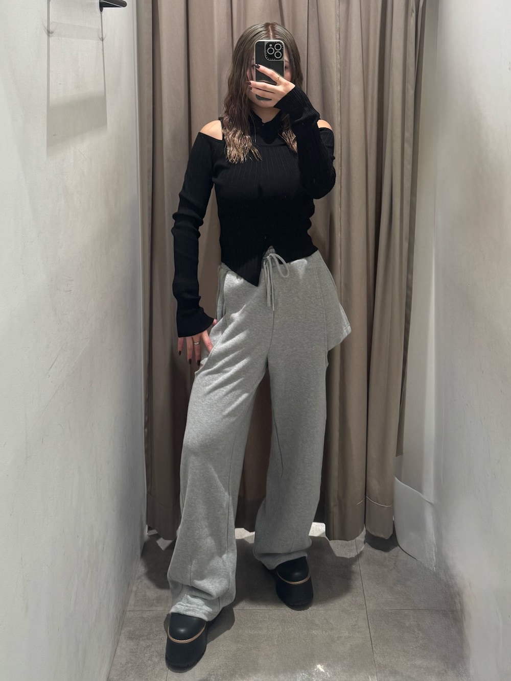 グレー系のスウェットパンツ、ブラック系のニット/セーター、ブラック系のブーツを着用したレディースの秋コーディネートの1枚目の写真