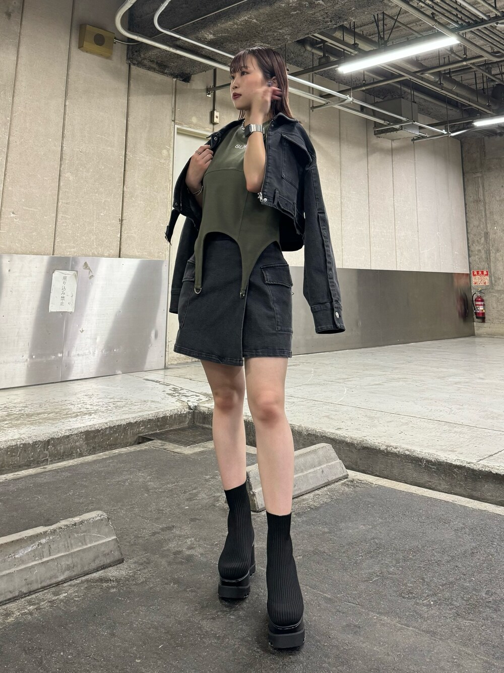 ブラック系のデニムジャケット、ブラック系のスカート、グリーン系のTシャツ/カットソーを着用したレディースの夏コーディネートの1枚目の写真