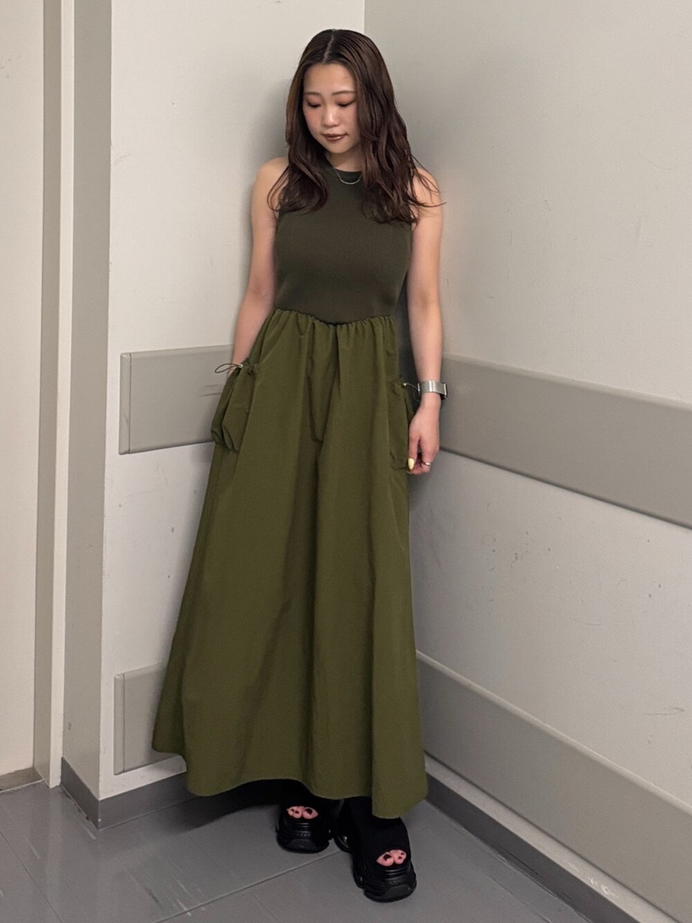 グリーン系のワンピース、ブラック系のサンダルを着用したレディースの夏コーディネートの1枚目の写真