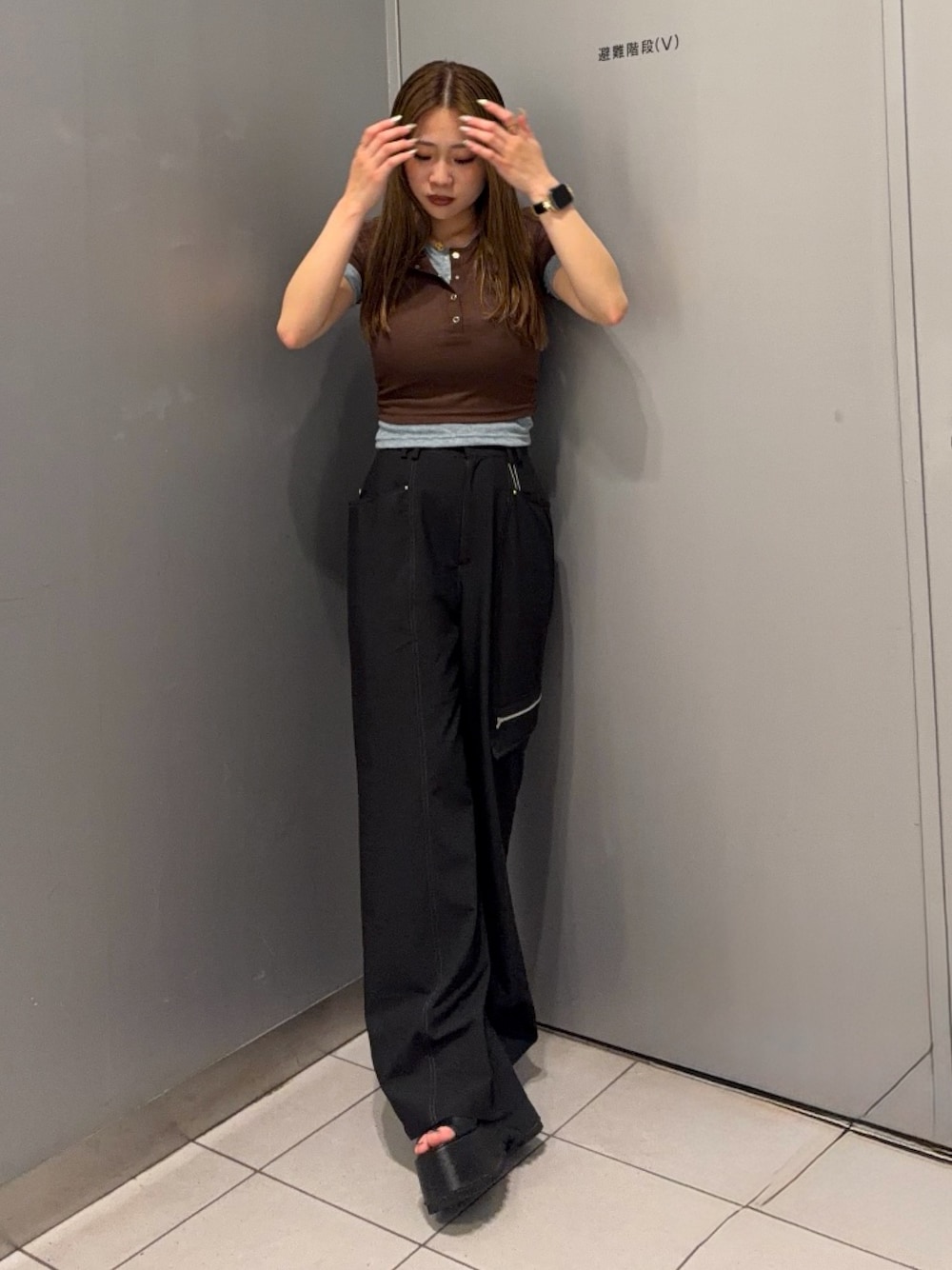 ブラック系のスラックス、ブラウン系のTシャツ/カットソー、ブラック系のブーツを着用したレディースの春コーディネートの1枚目の写真