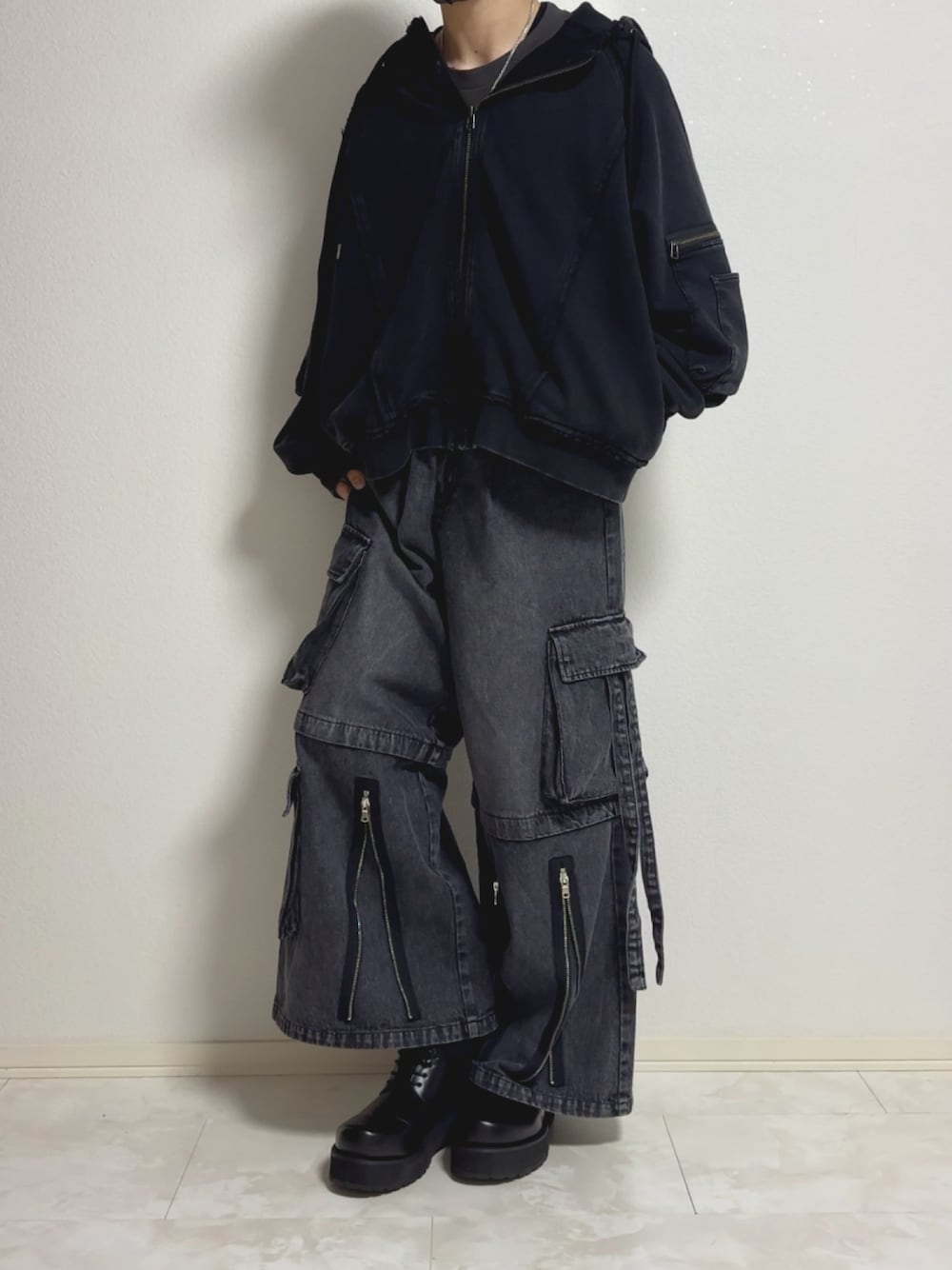 ブラック系のパーカー、ブラック系のデニムパンツ、ブラック系のドレスシューズを着用したメンズの冬コーディネートの1枚目の写真
