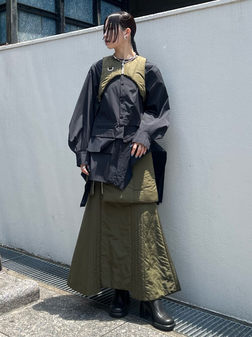 ベージュ系のスカート、ベージュ系のベスト、ブラック系のシャツ/ブラウスを着用したレディースの夏コーディネートの1枚目の写真