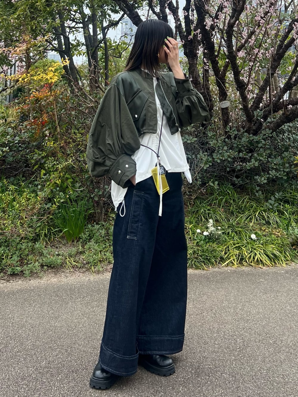 グリーン系のブルゾン、ホワイト系のTシャツ/カットソー、ブルー系のデニムパンツを着用したレディースの春コーディネートの1枚目の写真
