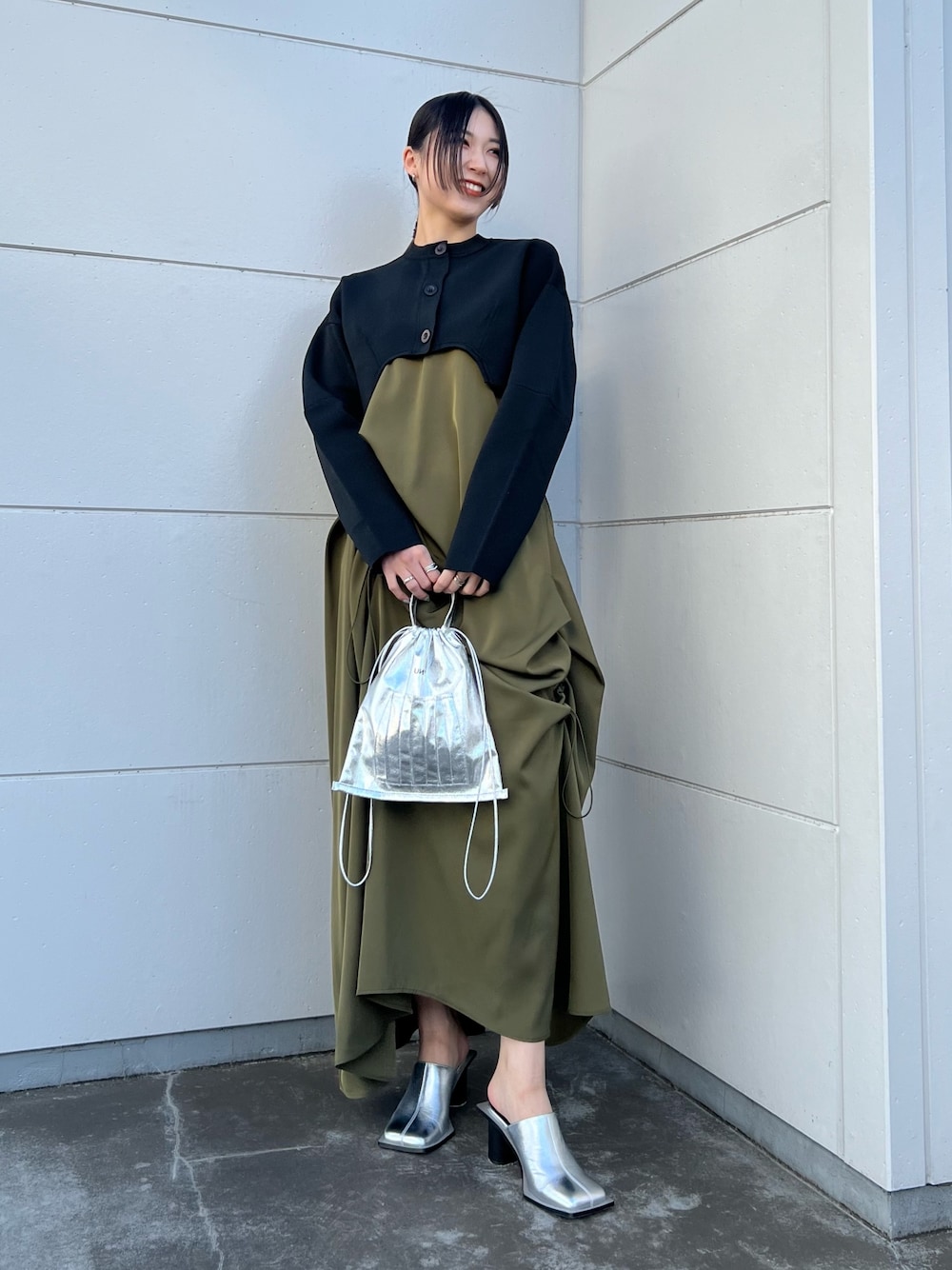 ブラック系のカーディガン/ボレロ、ベージュ系のワンピース、シルバー系のショルダーバッグを着用したレディースの春コーディネートの1枚目の写真