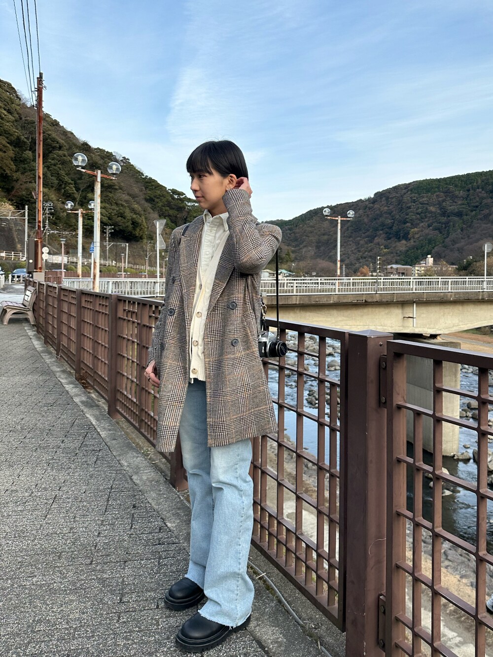 ブラウン系のチェスターコート、ベージュ系のトップスを着用したレディースの冬コーディネートの1枚目の写真