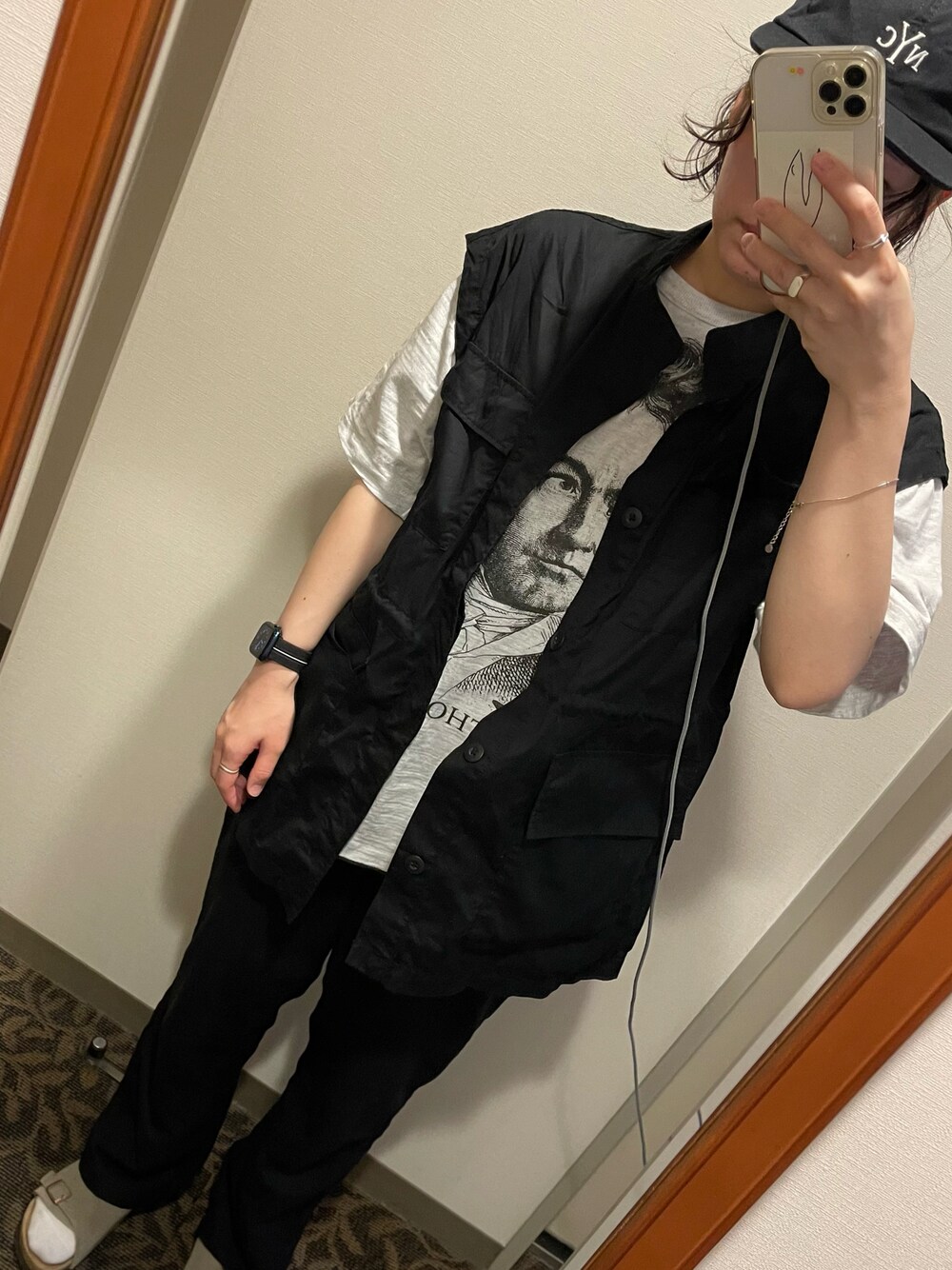 ブラック系のスラックス、ブラック系のベスト、ホワイト系のTシャツ/カットソーを着用したレディースの夏コーディネートの1枚目の写真