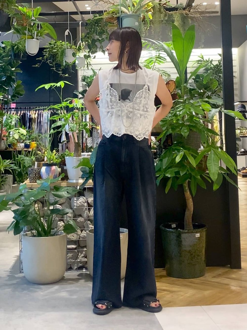 ベージュ系のショルダーバッグ、ブラック系のデニムパンツ、ブラック系のサンダルを着用したレディースの夏コーディネートの1枚目の写真