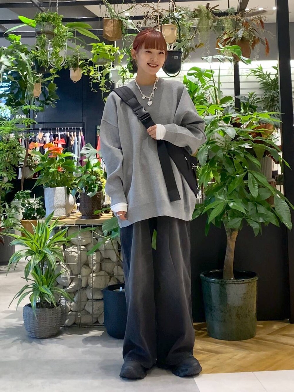 ホワイト系のTシャツ/カットソー、ブラック系のショルダーバッグ、グレー系のニット/セーターを着用したレディースの秋コーディネートの1枚目の写真