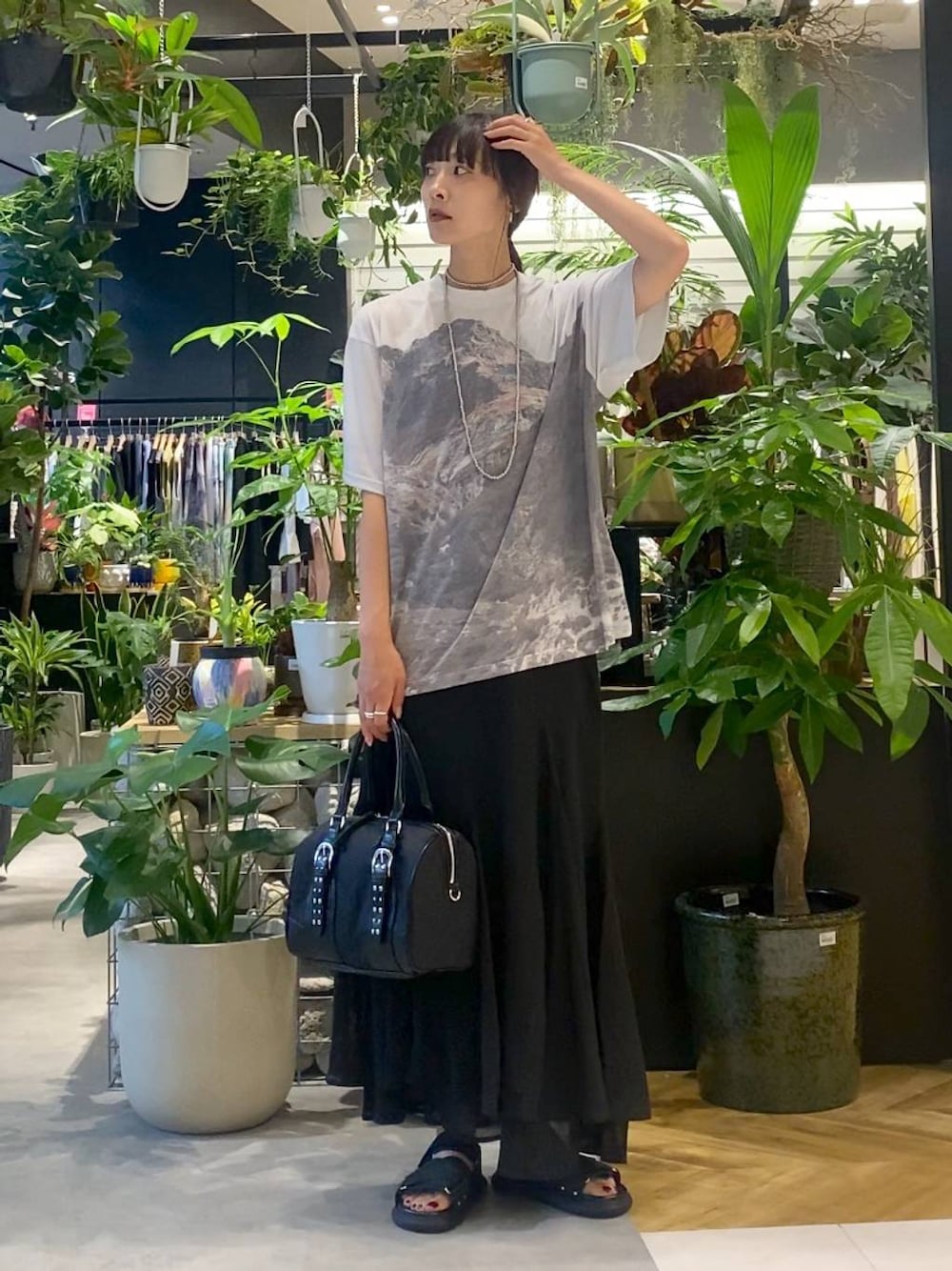 ブラック系のサンダル、グレー系のTシャツ/カットソー、ブラック系のスカートを着用したレディースの夏コーディネートの1枚目の写真