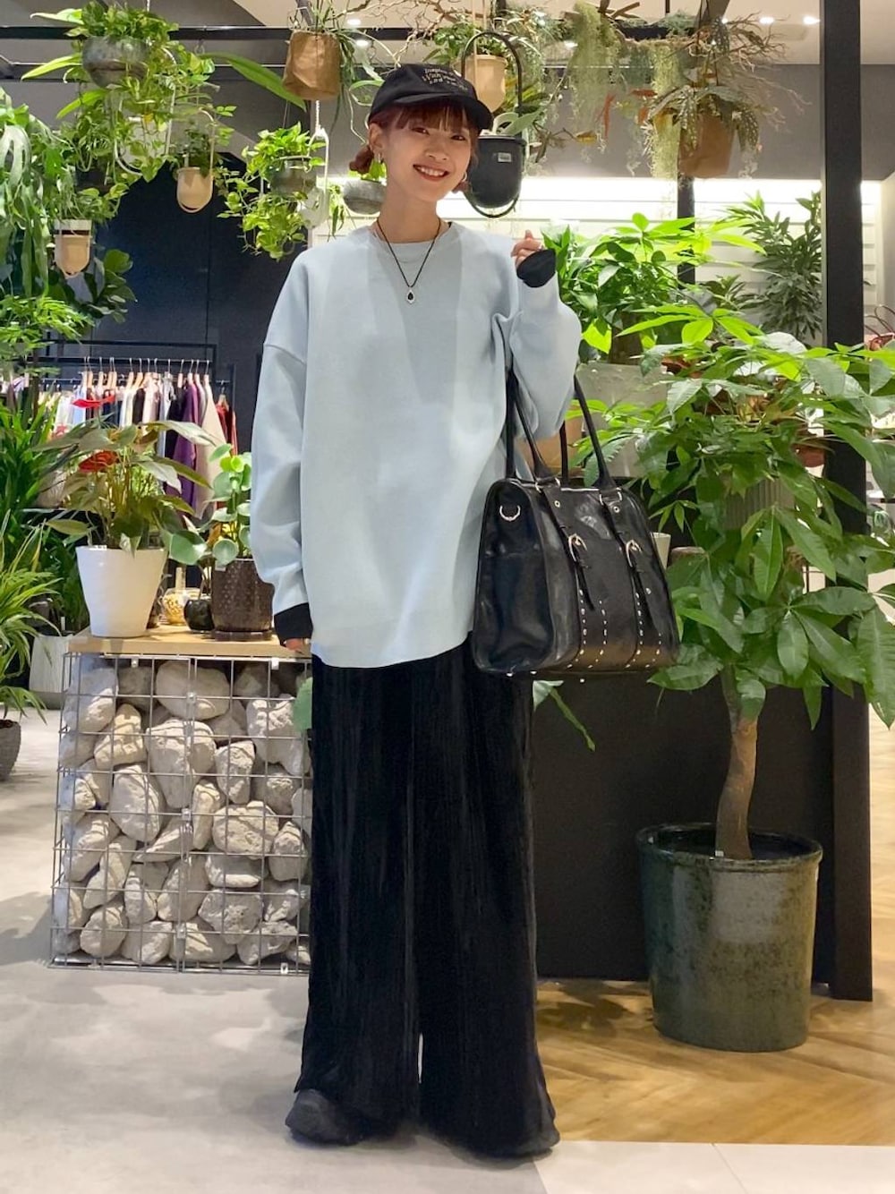 ブラック系のTシャツ/カットソー、ブルー系のニット/セーター、ブラック系のトートバッグを着用したレディースの秋コーディネートの1枚目の写真