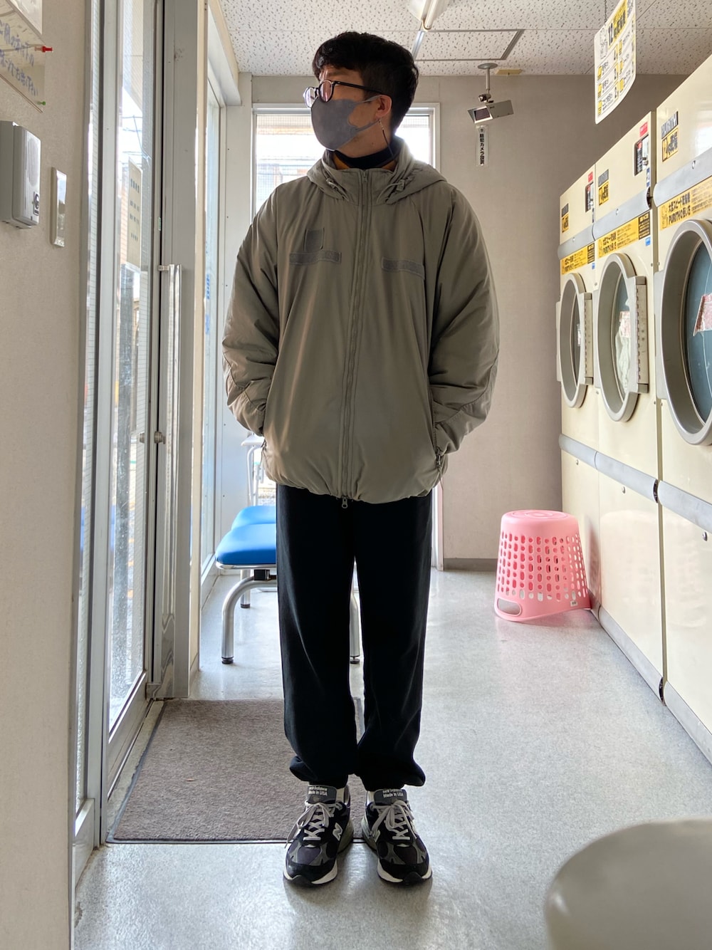 グリーン系のミリタリージャケット、イエロー系のその他アウター、ブラック系のニット/セーターを着用したメンズの冬コーディネートの1枚目の写真