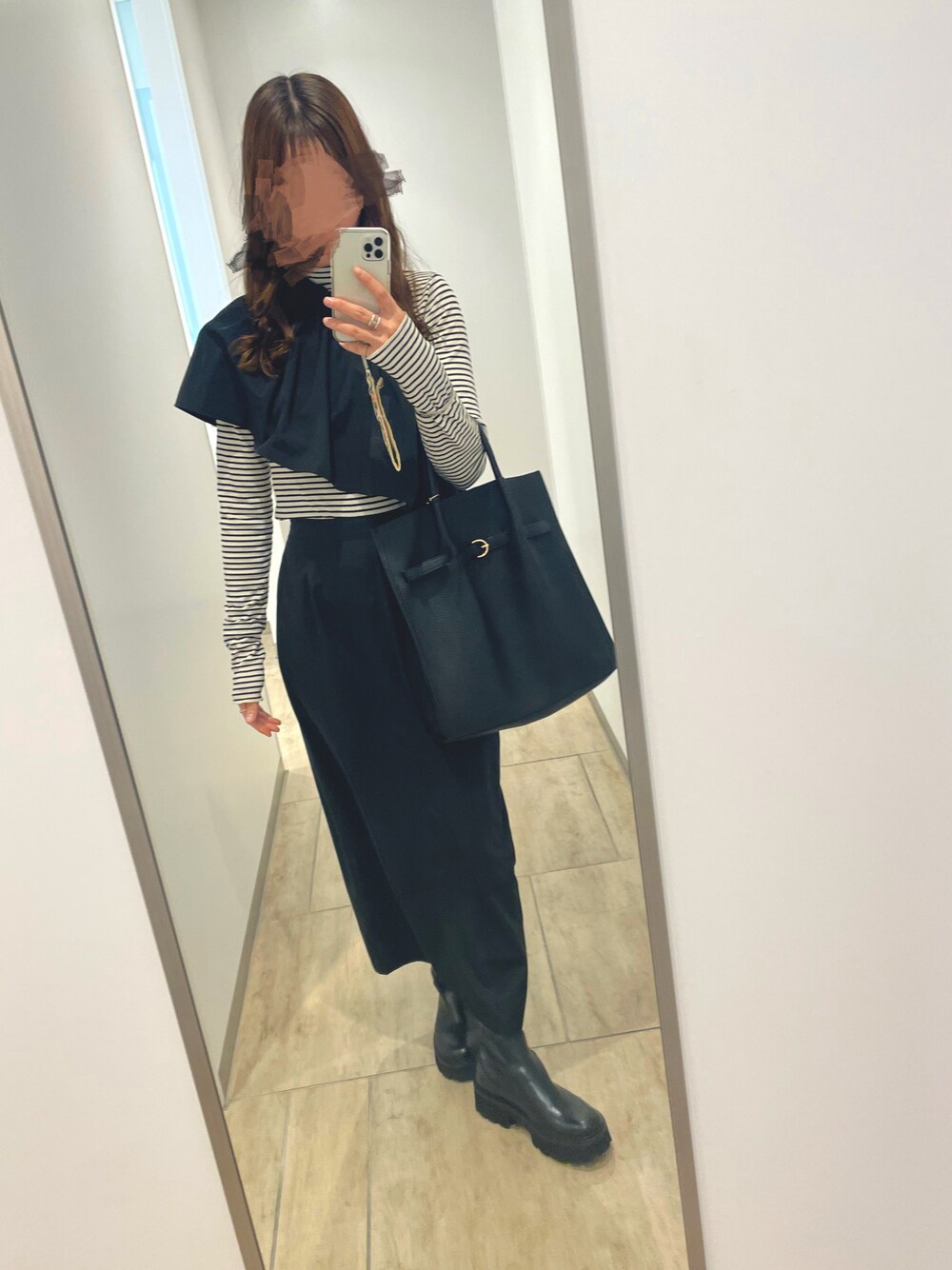 ブラック系のスカート、ブラック系のブーツを着用したレディースの秋コーディネートの1枚目の写真