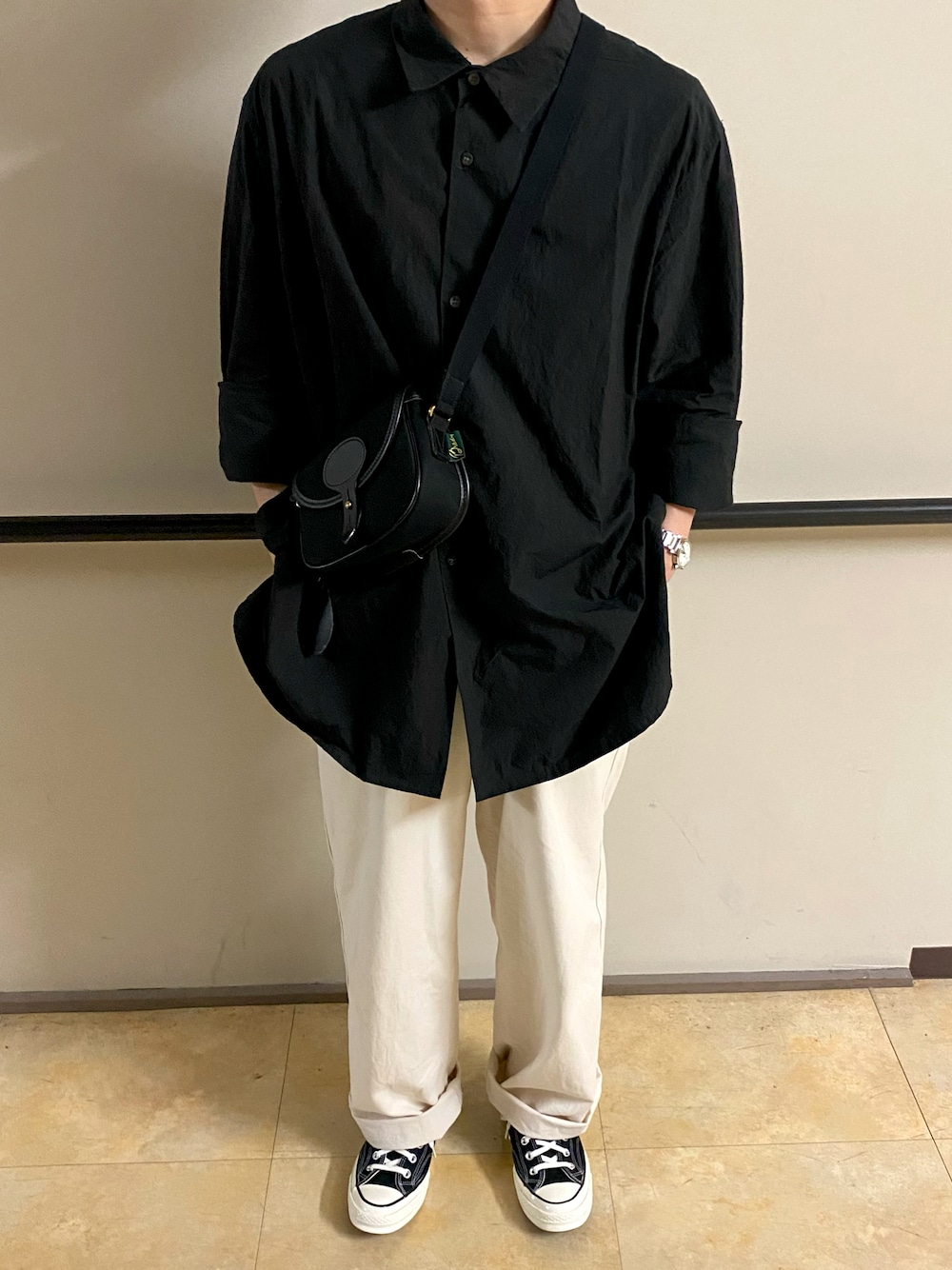 ブラック系のショルダーバッグ、ブラック系のシャツ/ブラウス、ホワイト系のその他パンツを着用したメンズの秋コーディネートの1枚目の写真