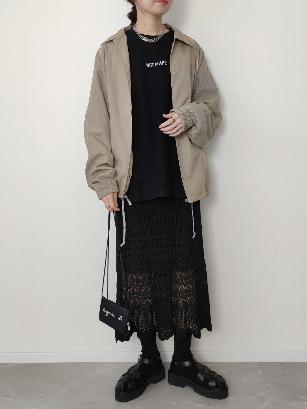 ベージュ系のナイロンジャケット、ブラック系のTシャツ/カットソー、ブラック系のソックス/靴下を着用したレディースの冬コーディネートの1枚目の写真