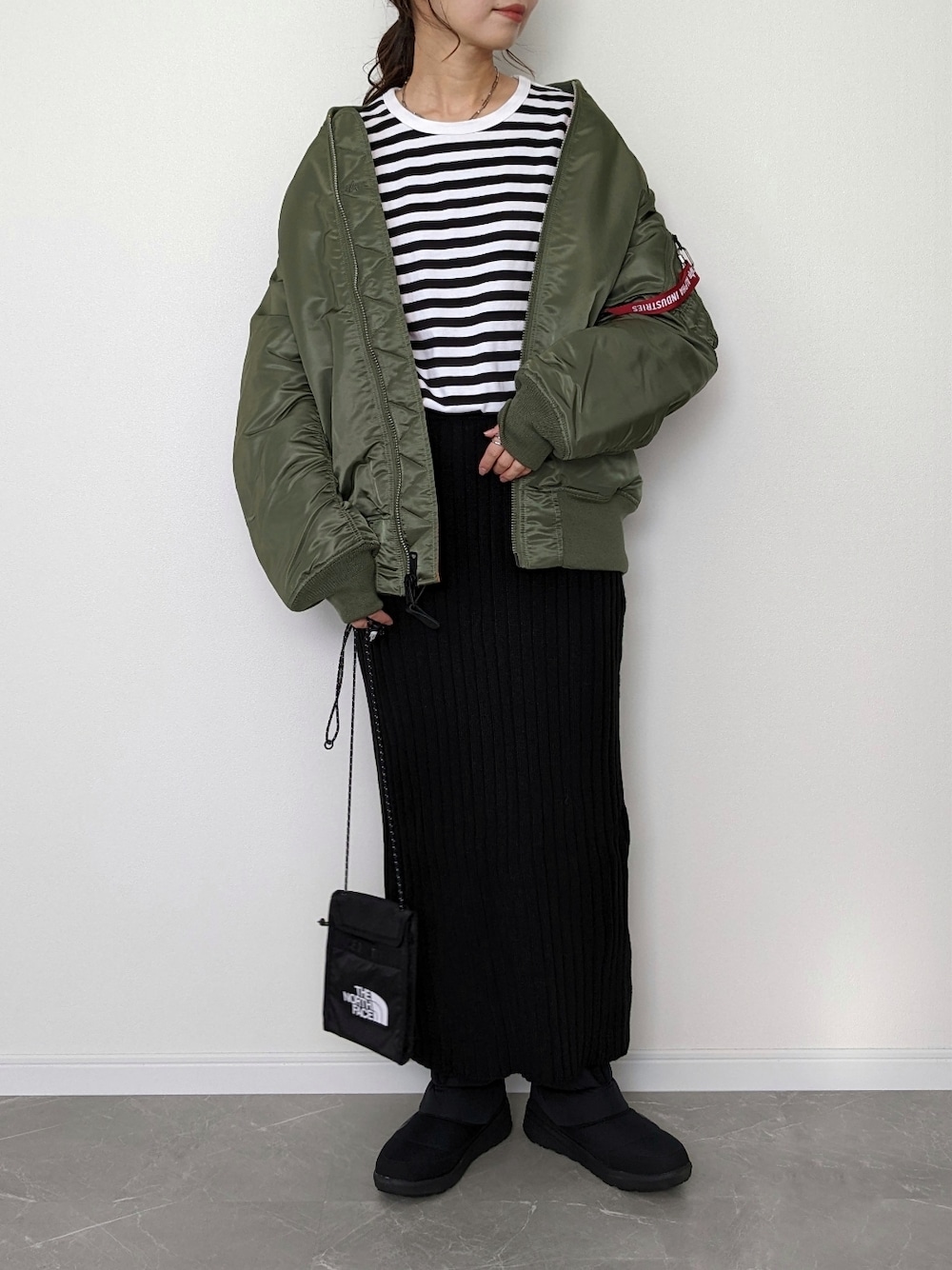 「MA-1、alpha、冬コーデ、冬アウター、ボーダー、ニットスカート、タイトスカート、ブーツ、ヌプシ、THE NORTH FACE、大人カジュアル、ミリタリー、クリスマスに着たい服、あったかコーデ、休日スタイル」｜「ALPHAのMA-1 CORE TALL（MA-1、グリーン系）」を使った、HALさん（レディース・162cm）の冬コーディネートの1枚目の写真