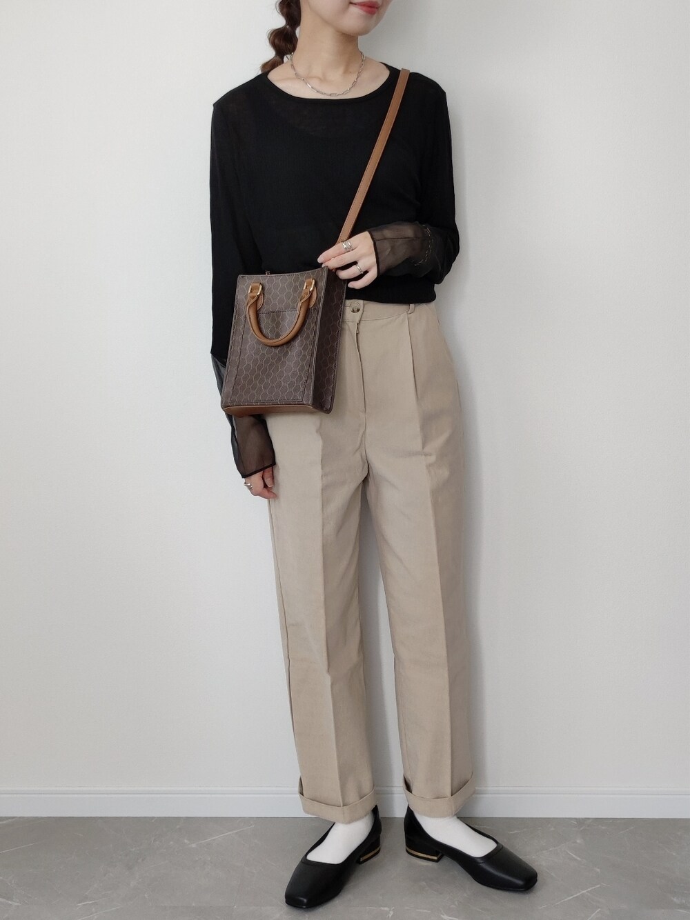 ブラウン系のショルダーバッグ、ブラック系のTシャツ/カットソー、ブラック系のパンプスを着用したレディースの夏コーディネートの1枚目の写真