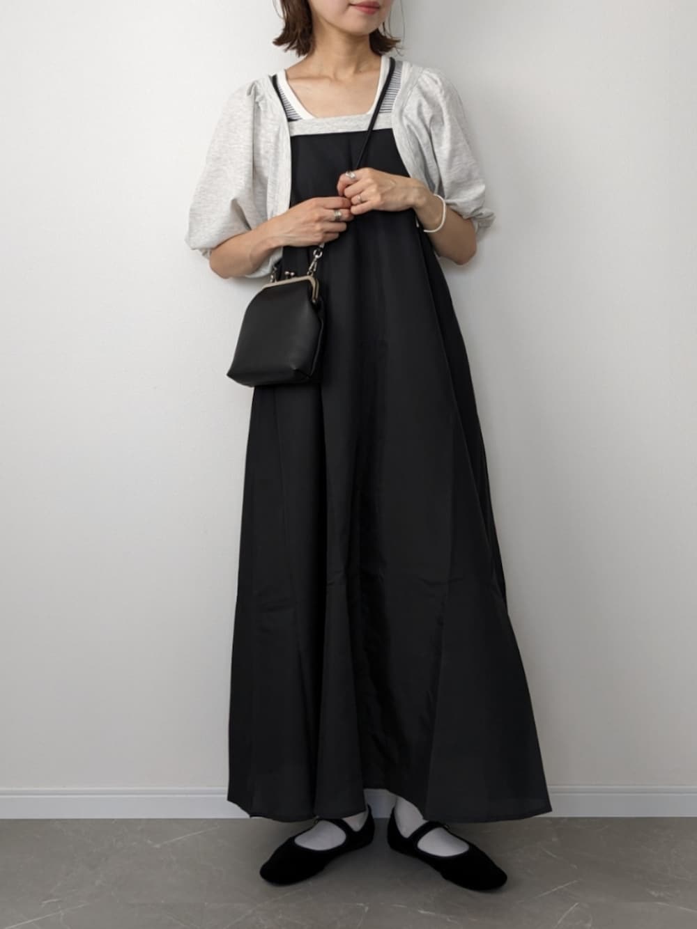 ベージュ系のワンピース、ブラック系のショルダーバッグ、ブラック系のパンプスを着用したレディースの夏コーディネートの1枚目の写真