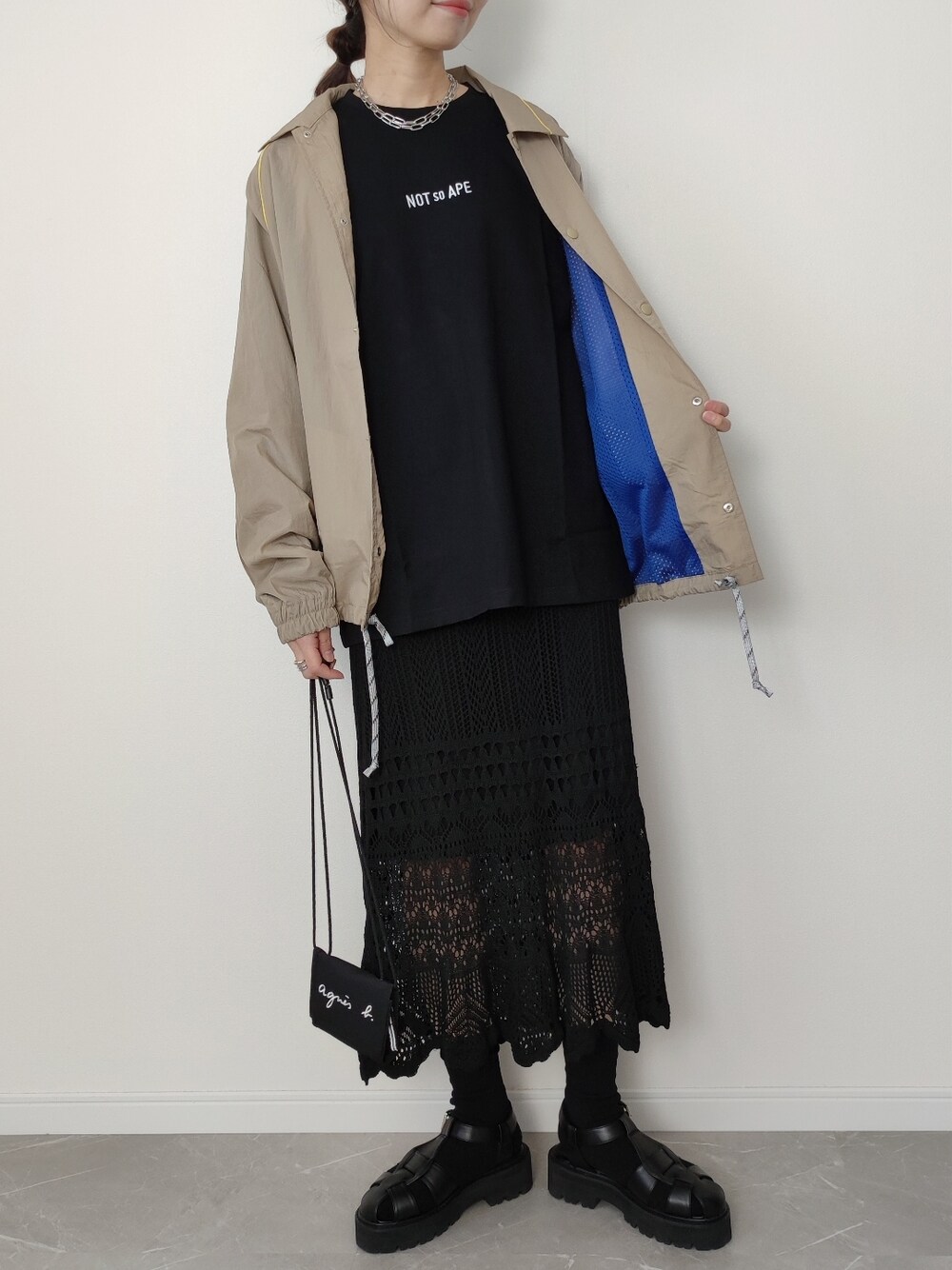 ベージュ系のナイロンジャケット、ブラック系のTシャツ/カットソー、ブラック系のソックス/靴下を着用したレディースの冬コーディネートの2枚目の写真