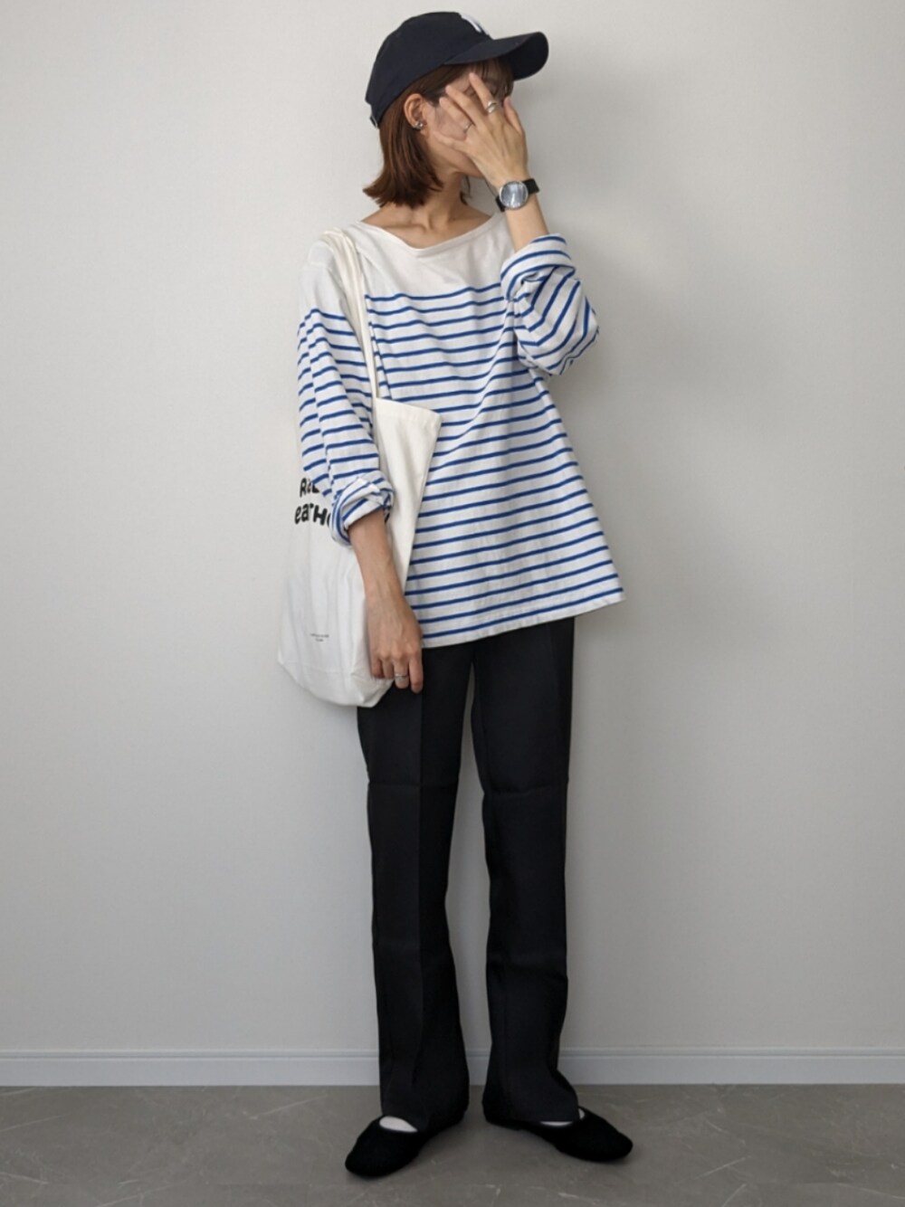 ブラック系のスラックス、ブルー系のTシャツ/カットソー、ブルー系のトートバッグを着用したレディースの夏コーディネートの1枚目の写真