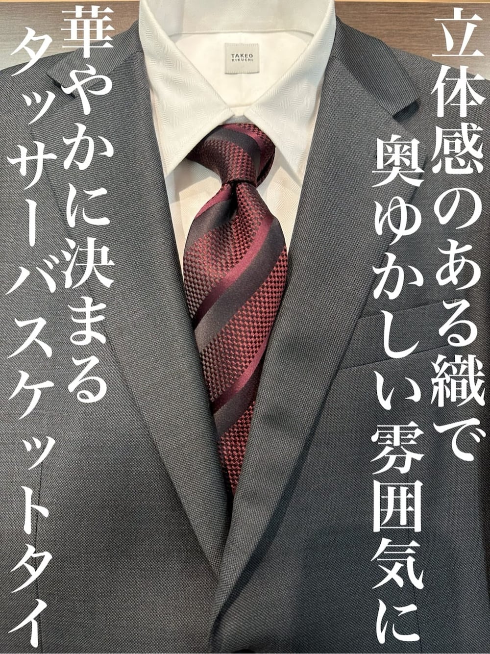 レッド系のネクタイ、グレー系のスーツセット、ホワイト系のビジネスシャツを着用したメンズの春コーディネートの1枚目の写真