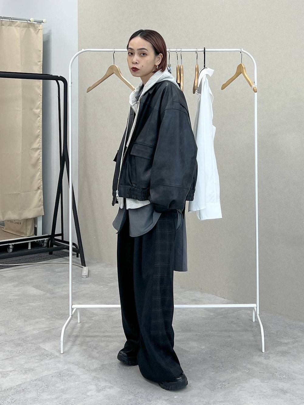 ブラック系のスニーカー、ブラック系のスラックス、ブラック系のハンドバッグを着用したレディースの秋コーディネートの1枚目の写真