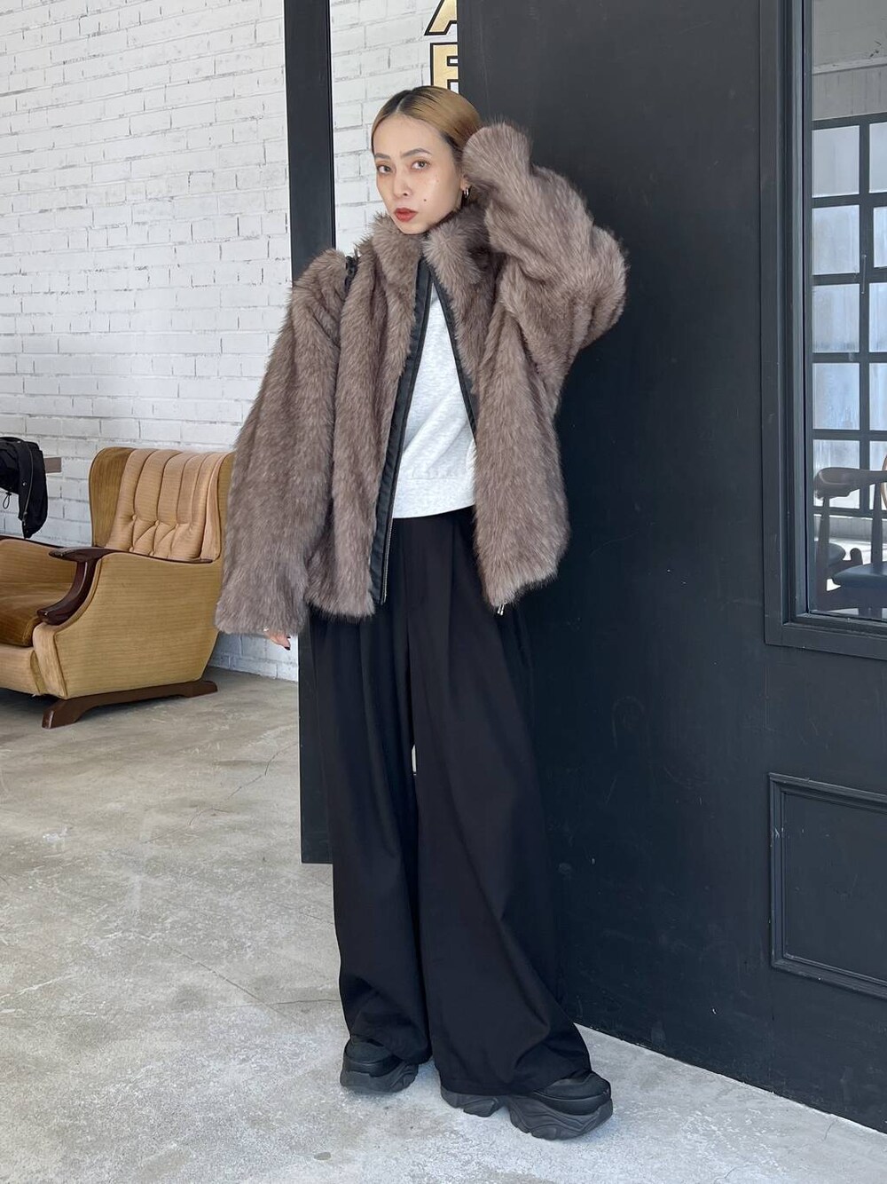 ブラック系のショルダーバッグ、ブラウン系のブルゾンを着用したレディースの秋コーディネートの1枚目の写真