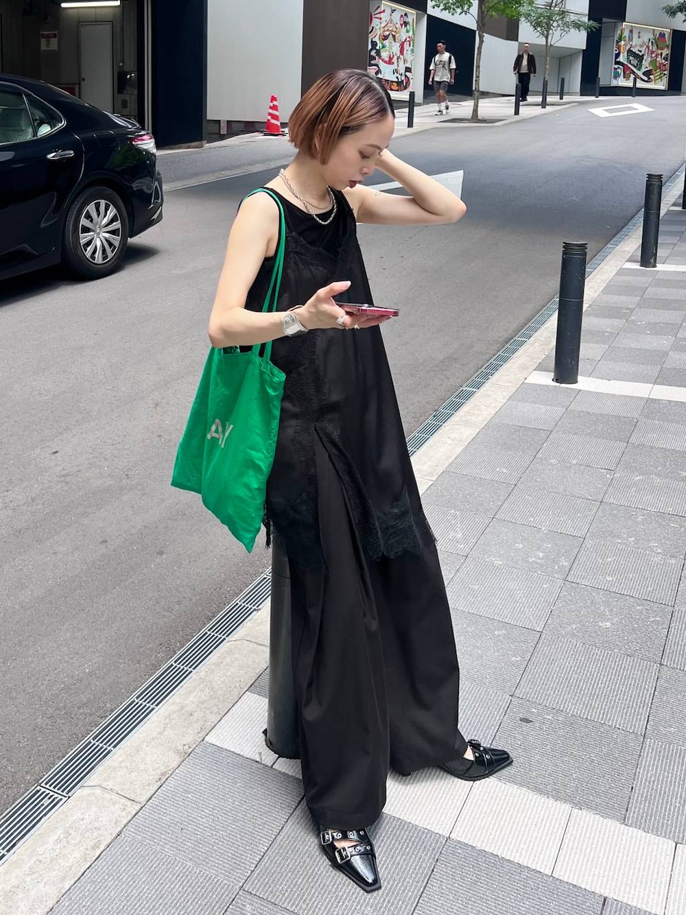 ブラック系のチュニック、ブラック系のスラックス、ブラック系のタンクトップを着用したレディースの夏コーディネートの1枚目の写真