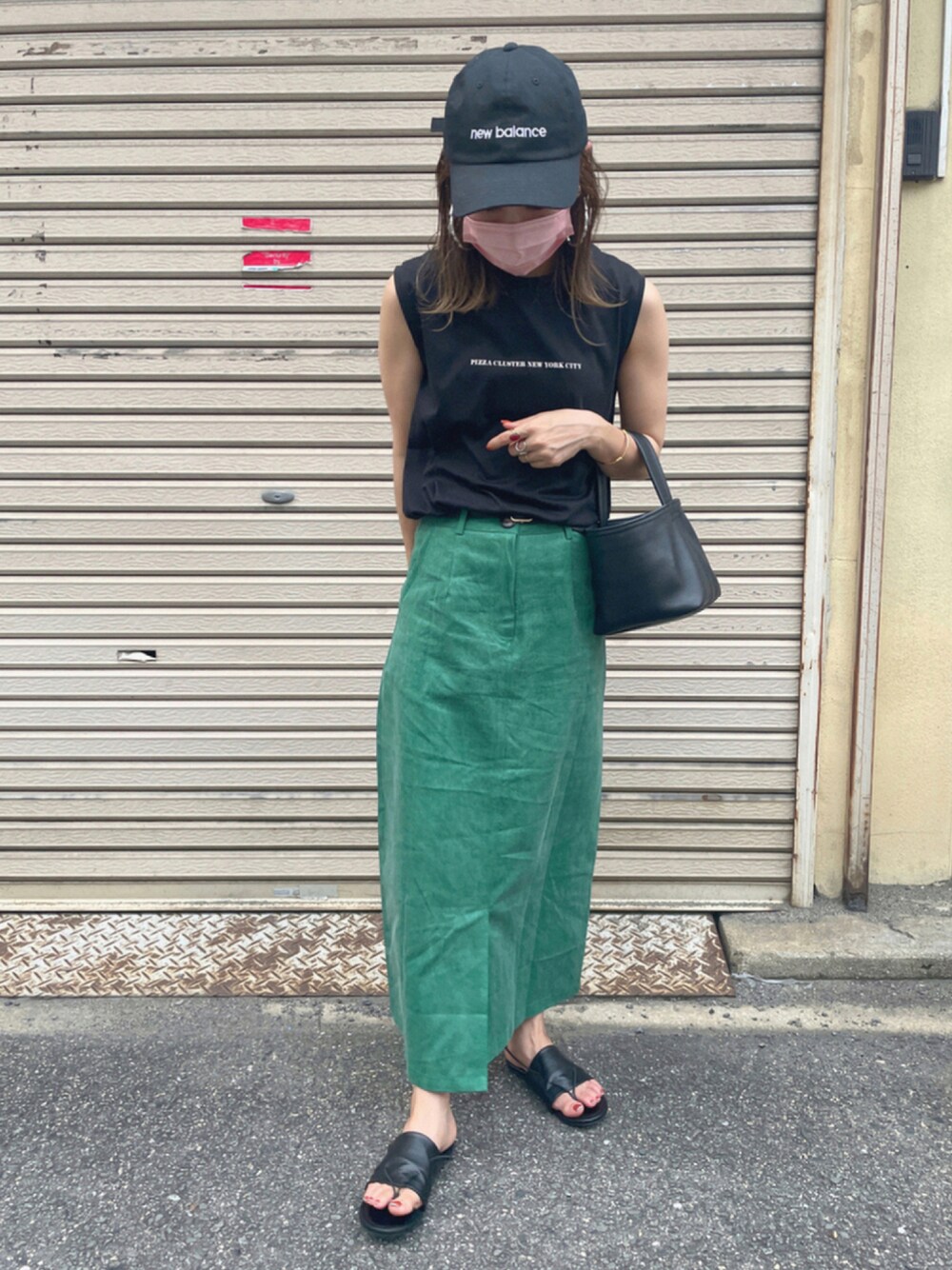 グリーン系のデニムスカート、ブラック系のTシャツ/カットソー、ブラック系のサンダルを着用したレディースの夏コーディネートの1枚目の写真