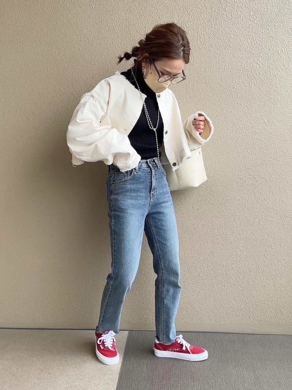 ホワイト系のデニムジャケット、ブルー系のデニムパンツ、レッド系のスニーカーを着用したレディースの冬コーディネートの1枚目の写真