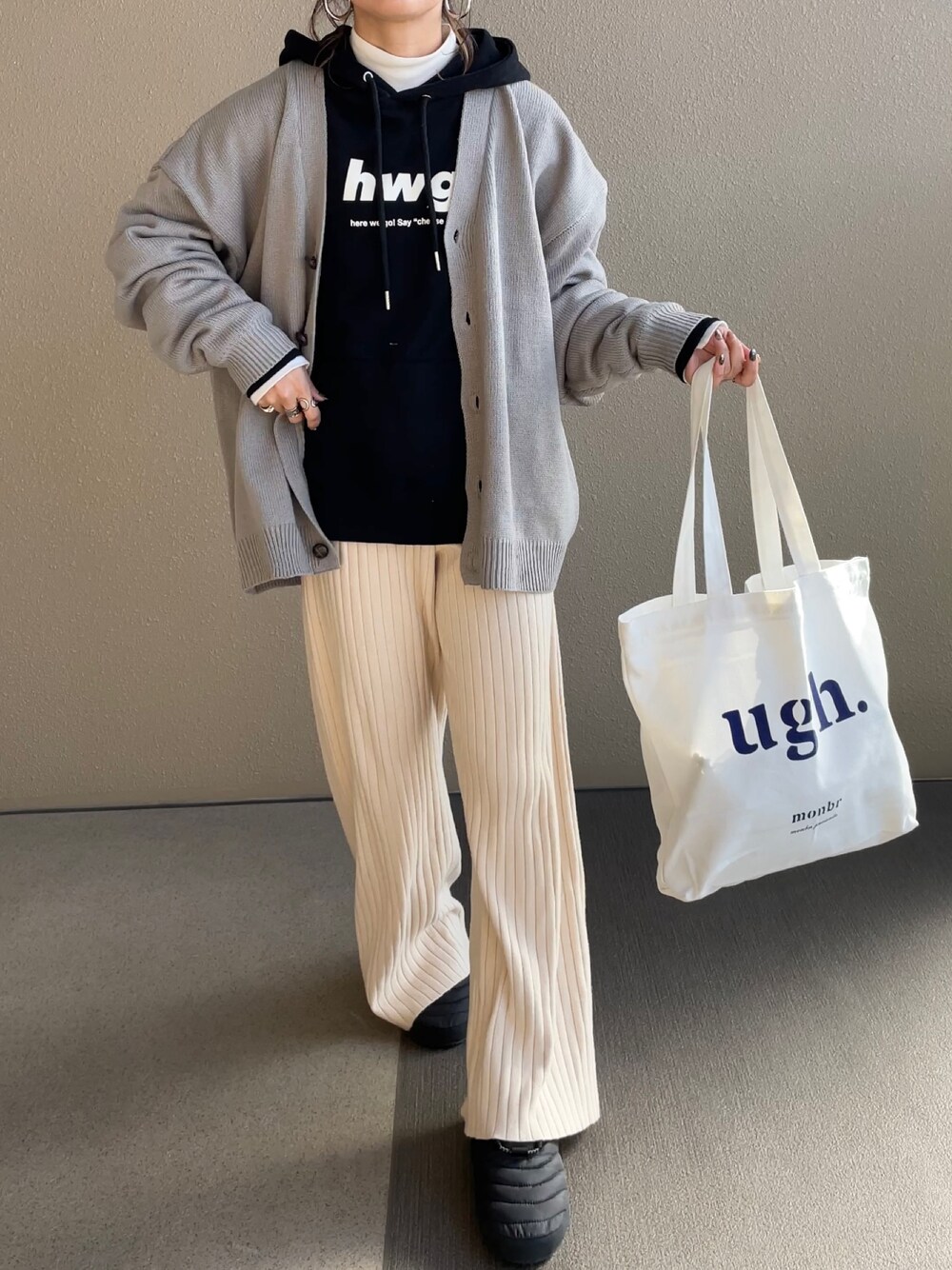 グレー系のカーディガン/ボレロ、ブラック系のパーカー、ベージュ系のその他パンツを着用したレディースの秋コーディネートの1枚目の写真