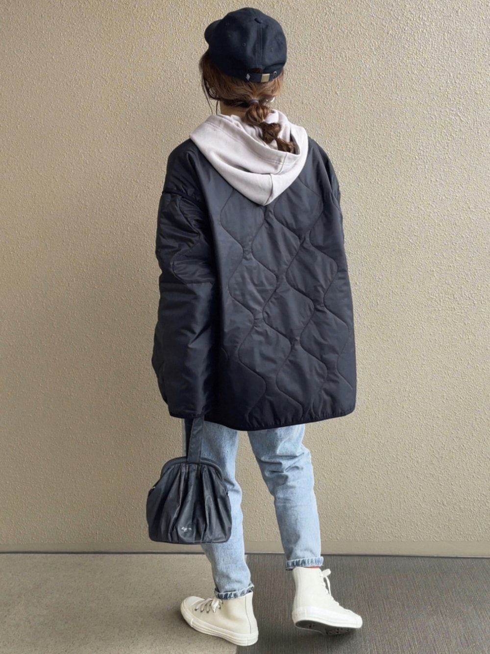 ブラック系のミリタリージャケット、グレー系のパーカー、ブルー系のデニムパンツを着用したレディースの秋コーディネートの1枚目の写真