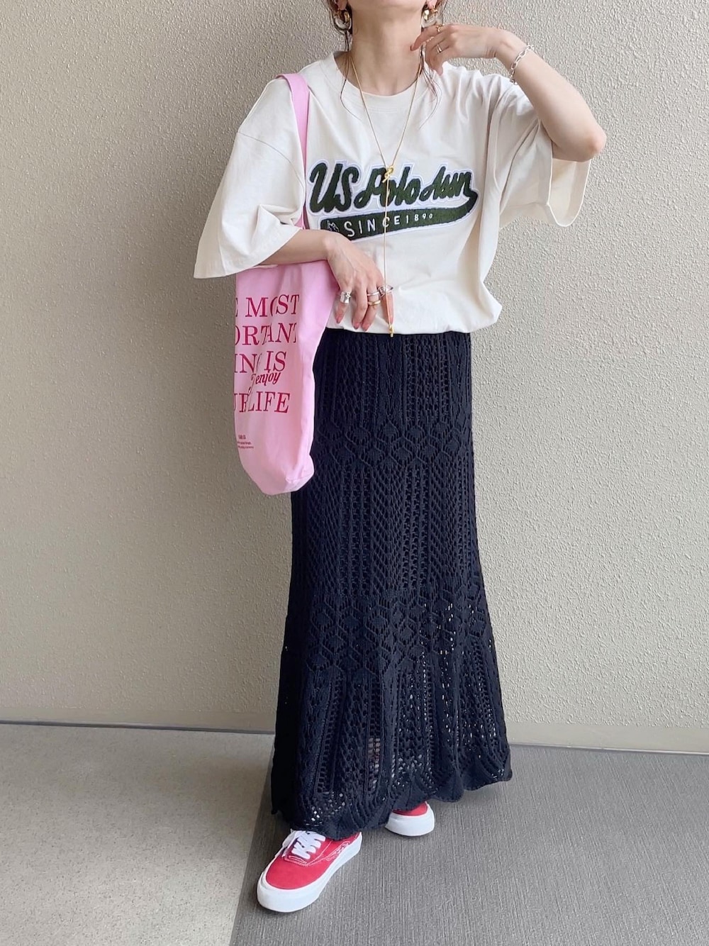 ベージュ系のTシャツ/カットソー、ブラック系のスカート、ピンク系のトートバッグを着用したレディースの春コーディネートの1枚目の写真